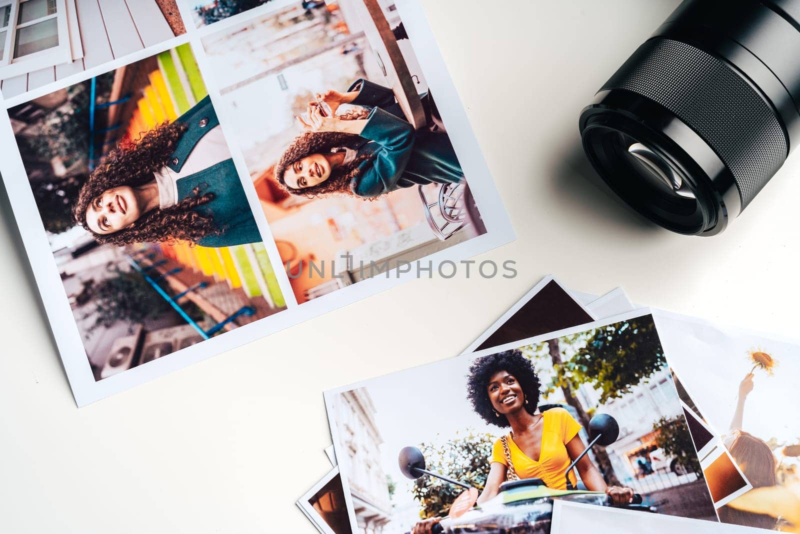 Camera and colorful printed photos of women on the desk close up