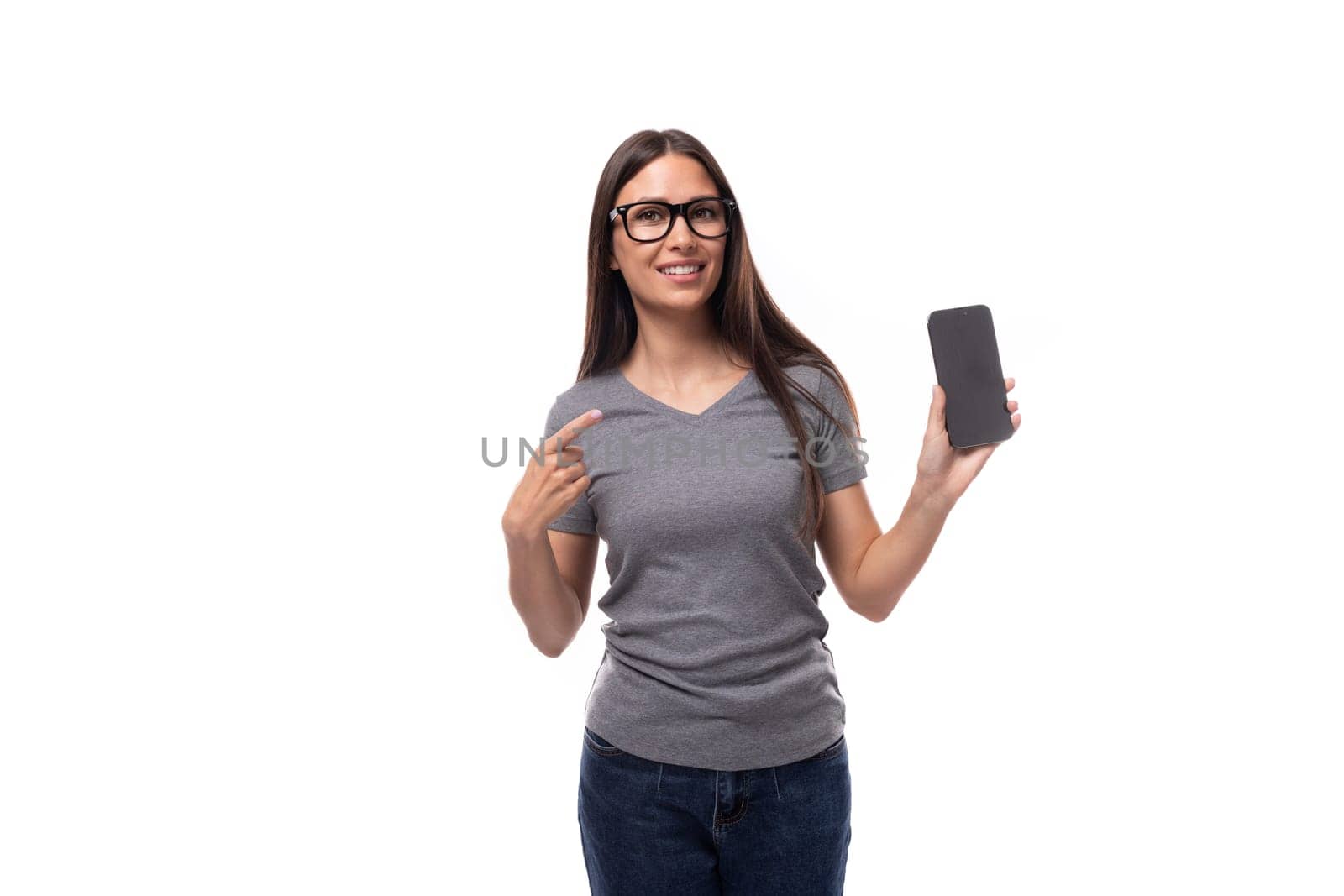portrait of a pensive caucasian slim young woman in glasses showing smartphone screen by TRMK