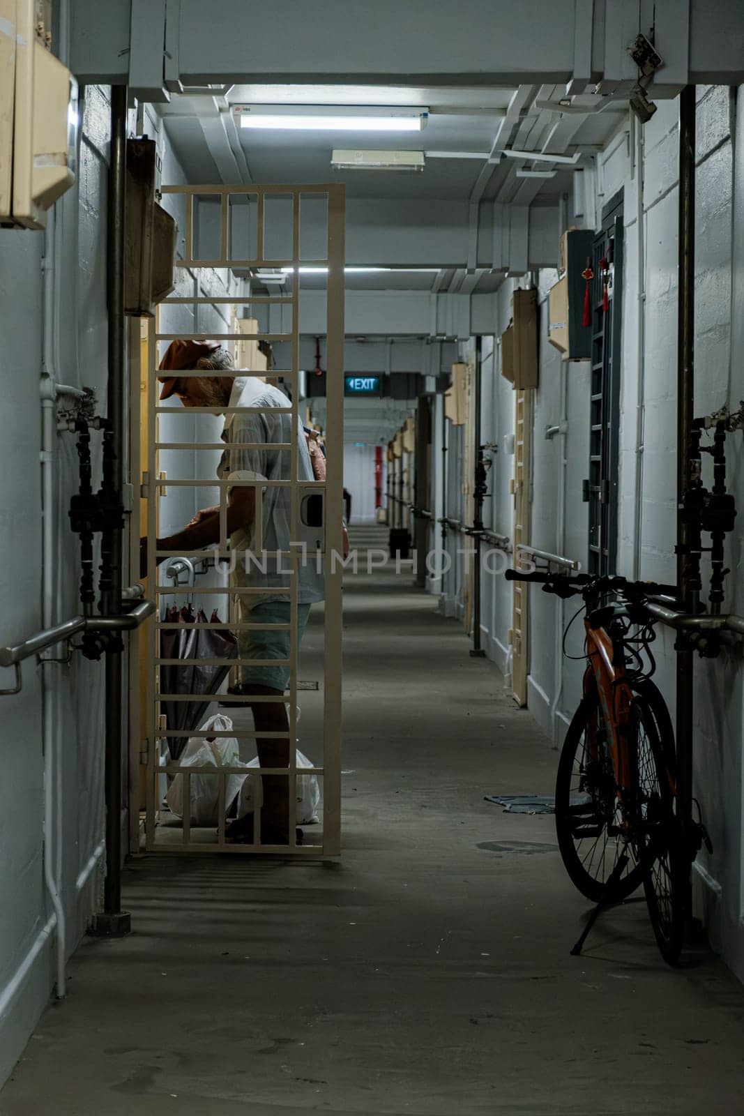 Elderly Man Entering Apartment of a Narrow Hallway by jinhongljh
