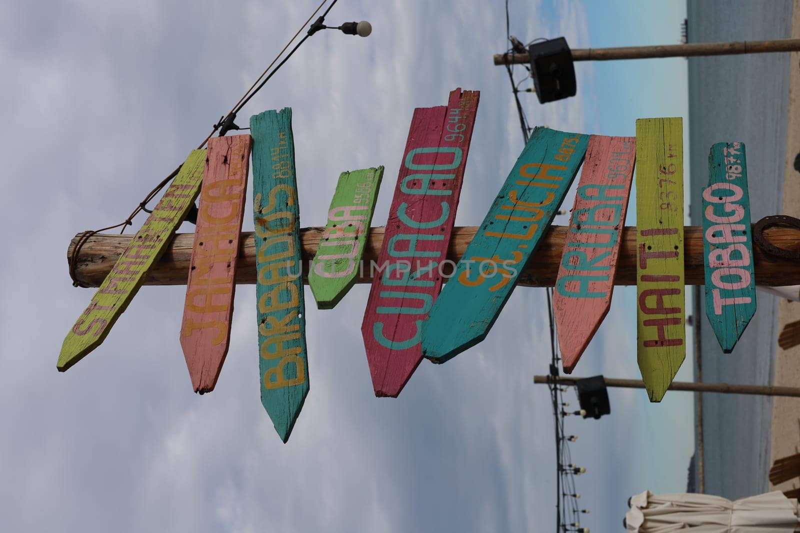 Signs on a beach pointing in different directions. High quality photo