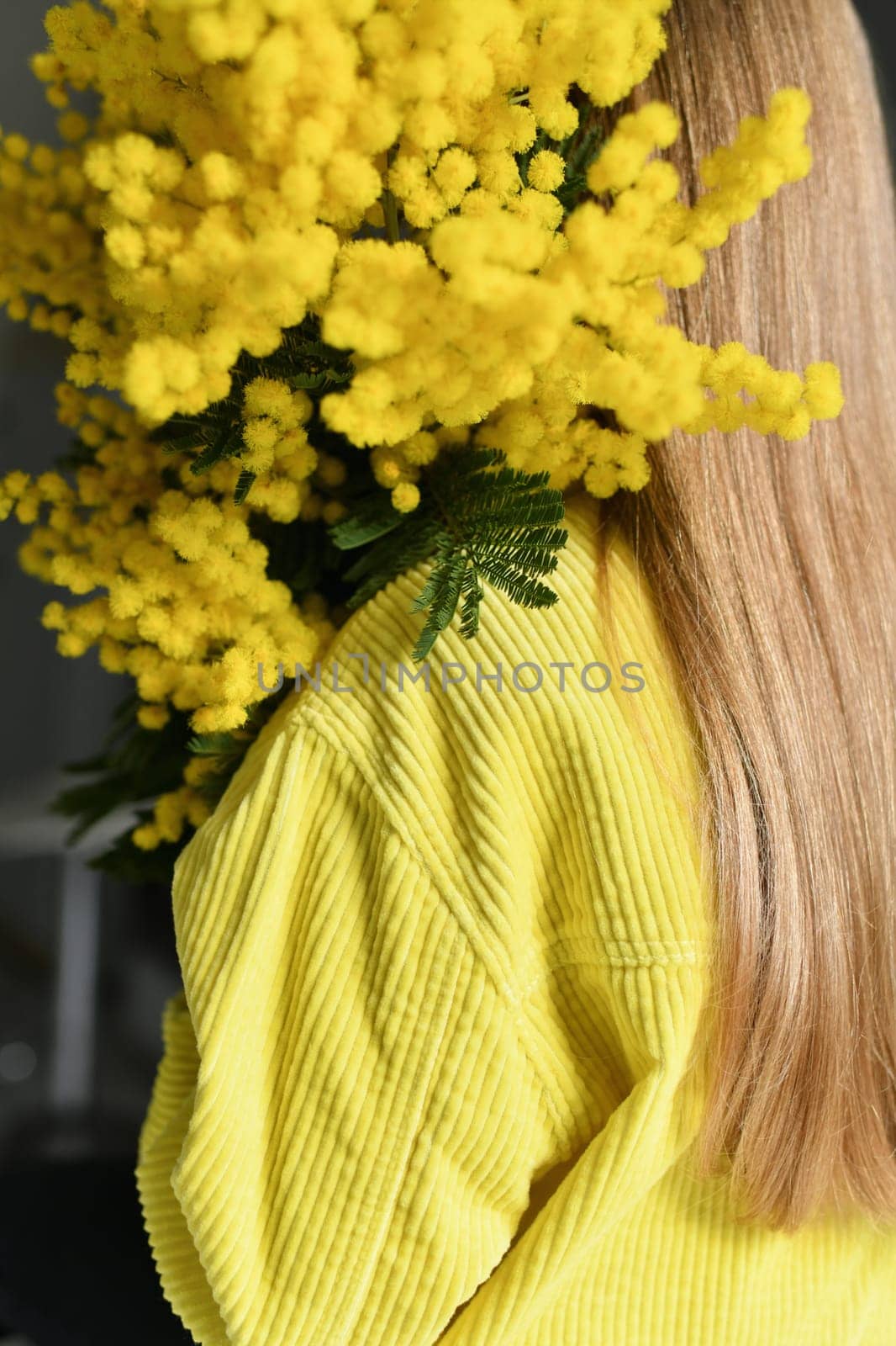 A girl holding a yellow mimosa