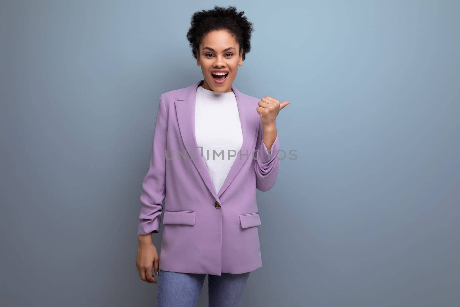 young successful positive office woman dressed in jacket points finger at wall space.