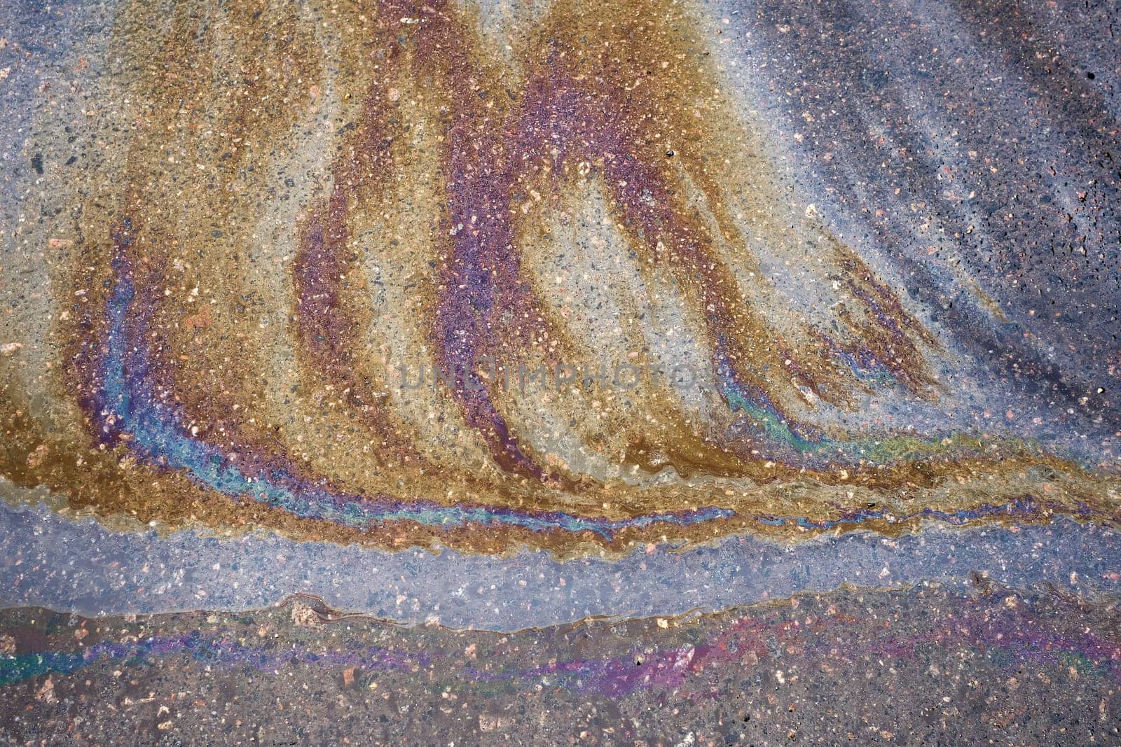 An oily iridescent stain of gasoline or oil spilled on the road