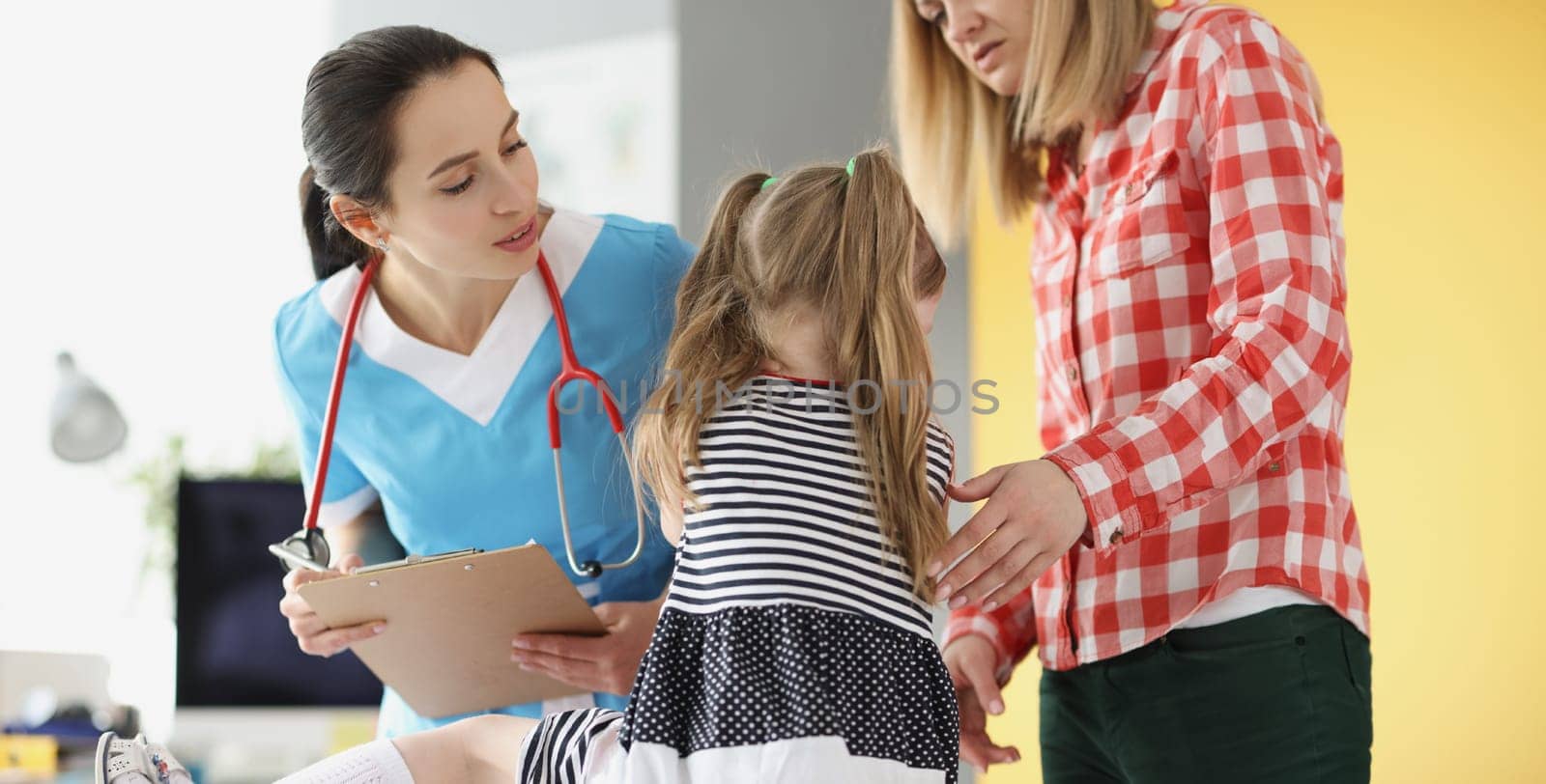 Little girl holding her neck at pediatrician doctor appointment. Diagnosis and treatment of myositis in children concept