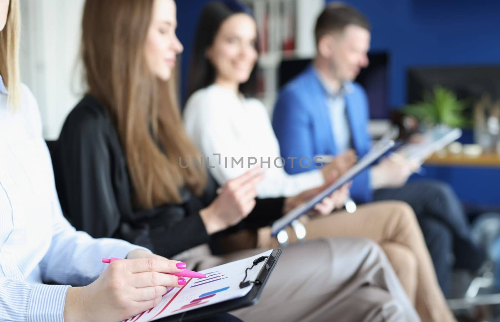 Group of people sitting at business seminar with documents and charts in their hands closeup. Conducting educational business meetings concept
