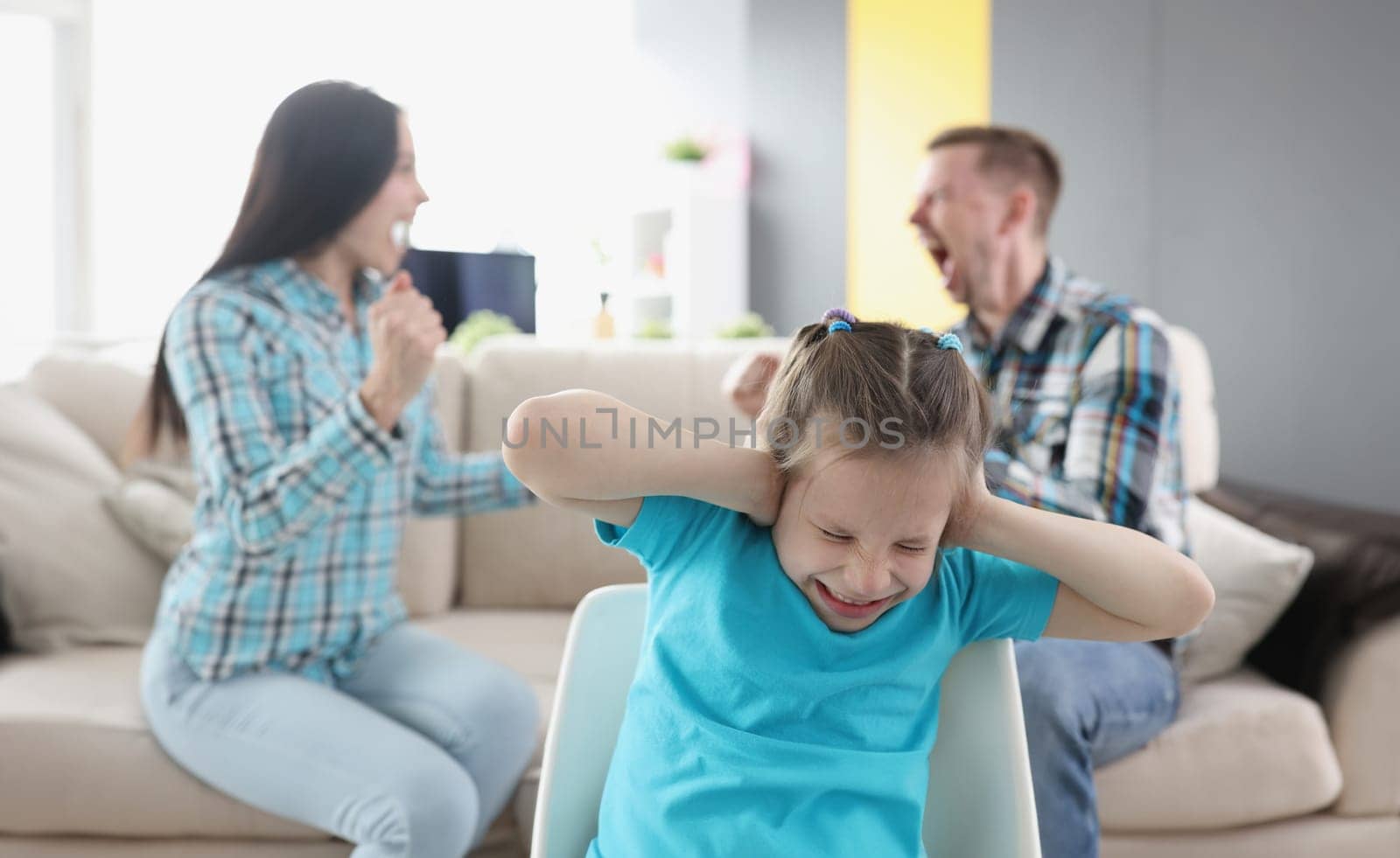 Little girl closing her ears against background of swearing parents at home by kuprevich