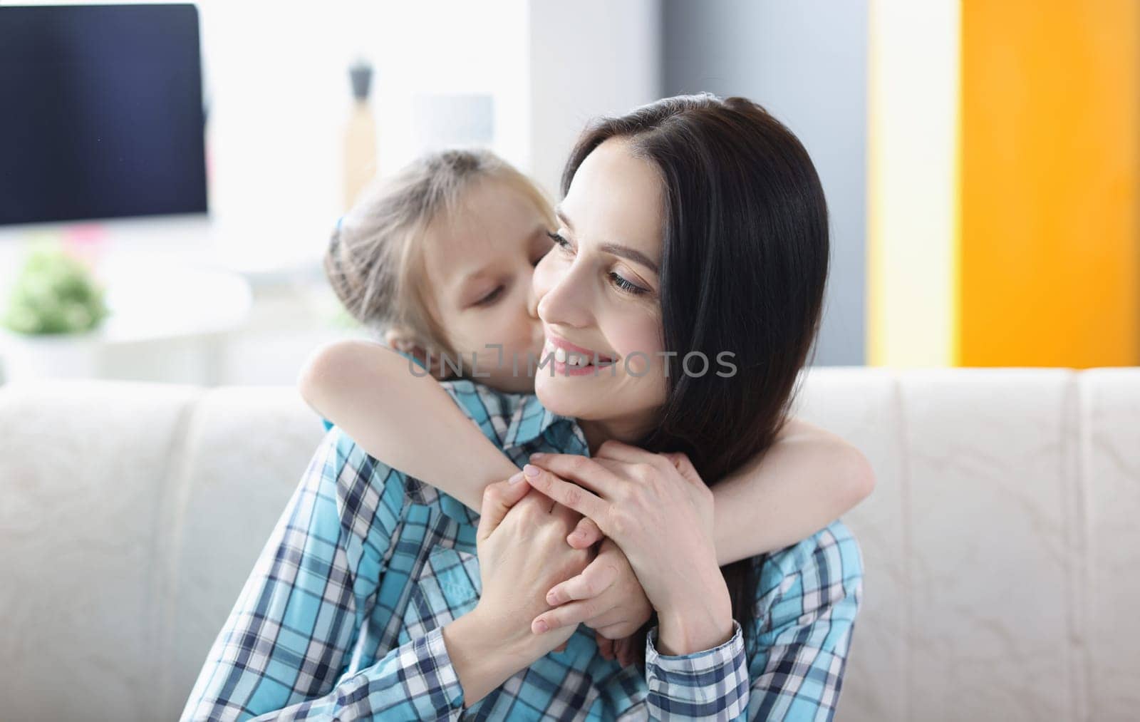 Little girl hugging young woman at home by kuprevich