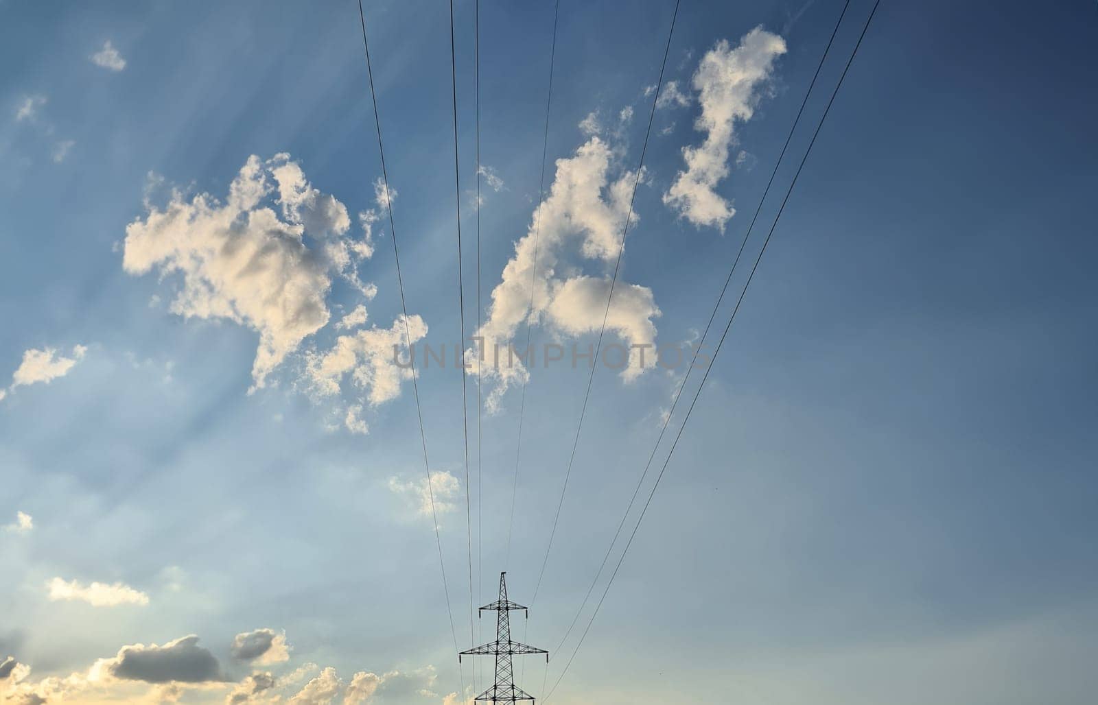 Electric wires from power lines on background of blue sky with clouds. Power supply concept