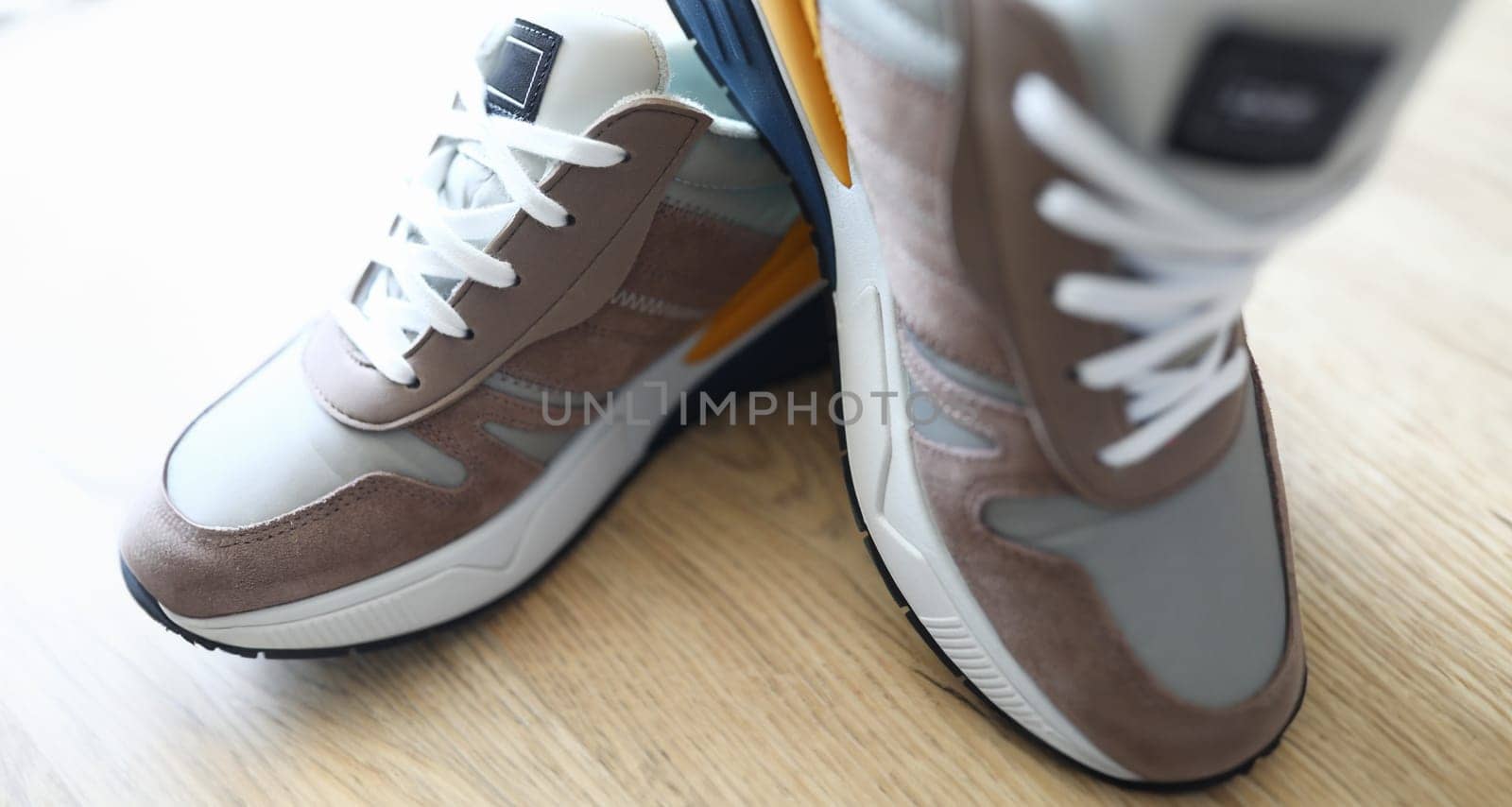 Close-up of grey sneakers on table. Sport footwear for running and fitness. Amazing and trendy pair of shoes. Active lifestyle. Nice texture with white sole and laces
