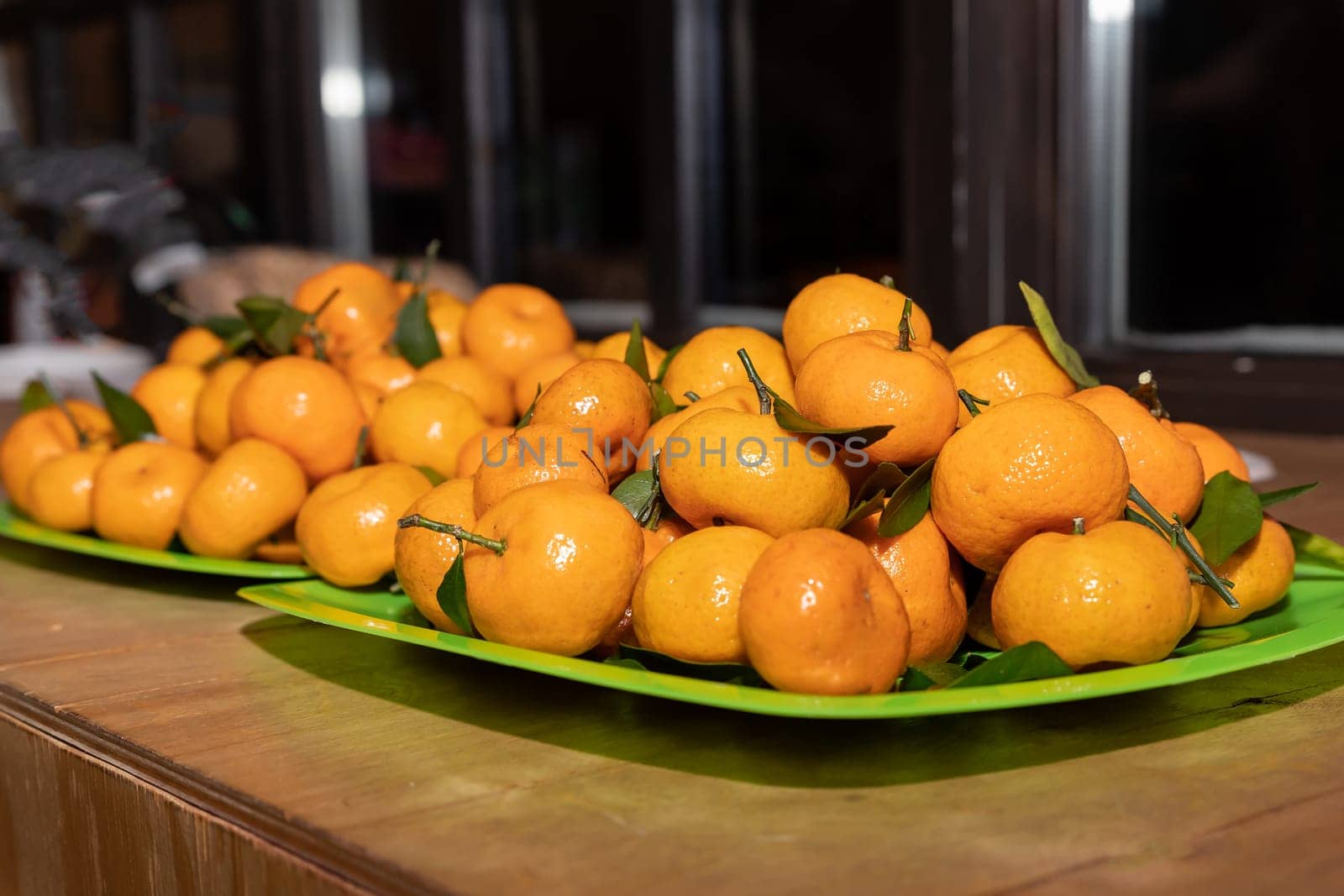 Ripe mandarin, citrus on green plate on blurred background. stack of fresh tangerines. Healthy food. symbol of new year time by YuliaYaspe1979