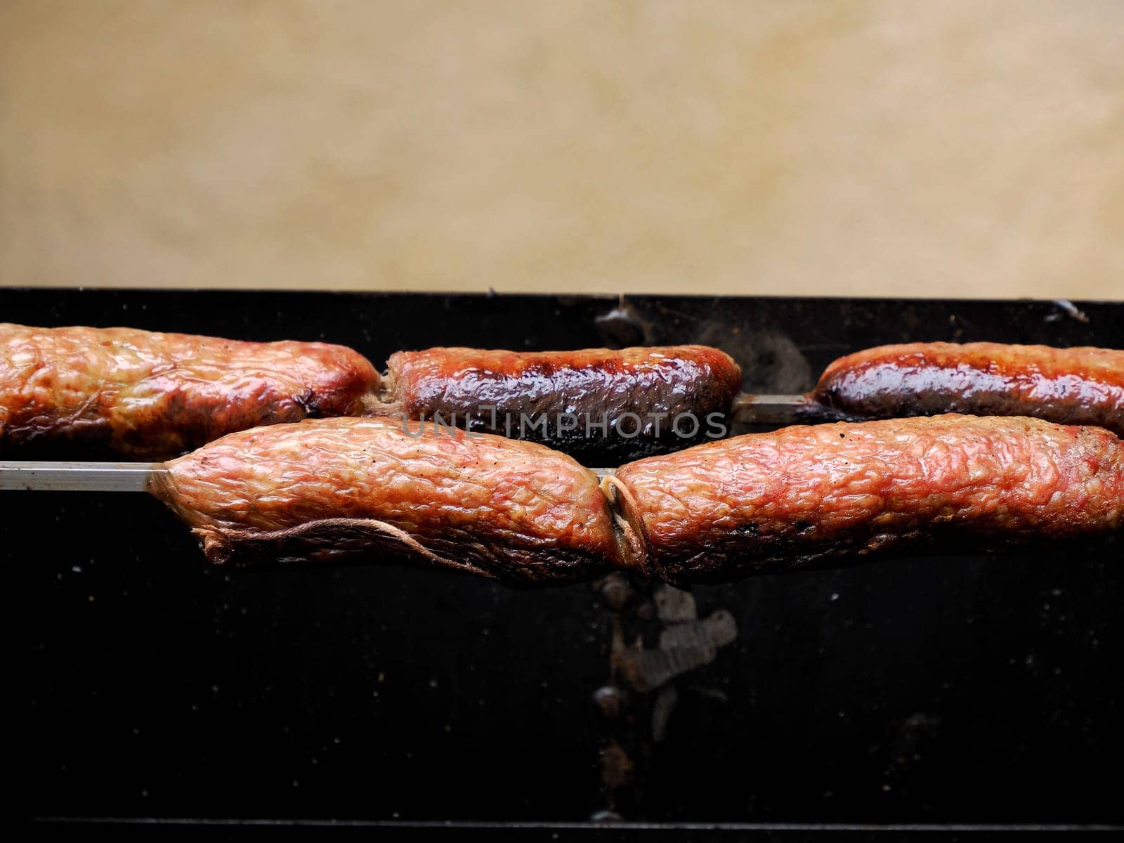 Grilling bavarian sausages on charcoal barbecue grill BBQ in the garden