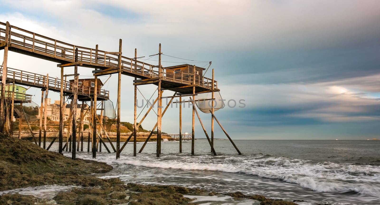 Traditional fisherman hut on stilts with carrelet fishing net. Typical wooden houses for fishing at beach