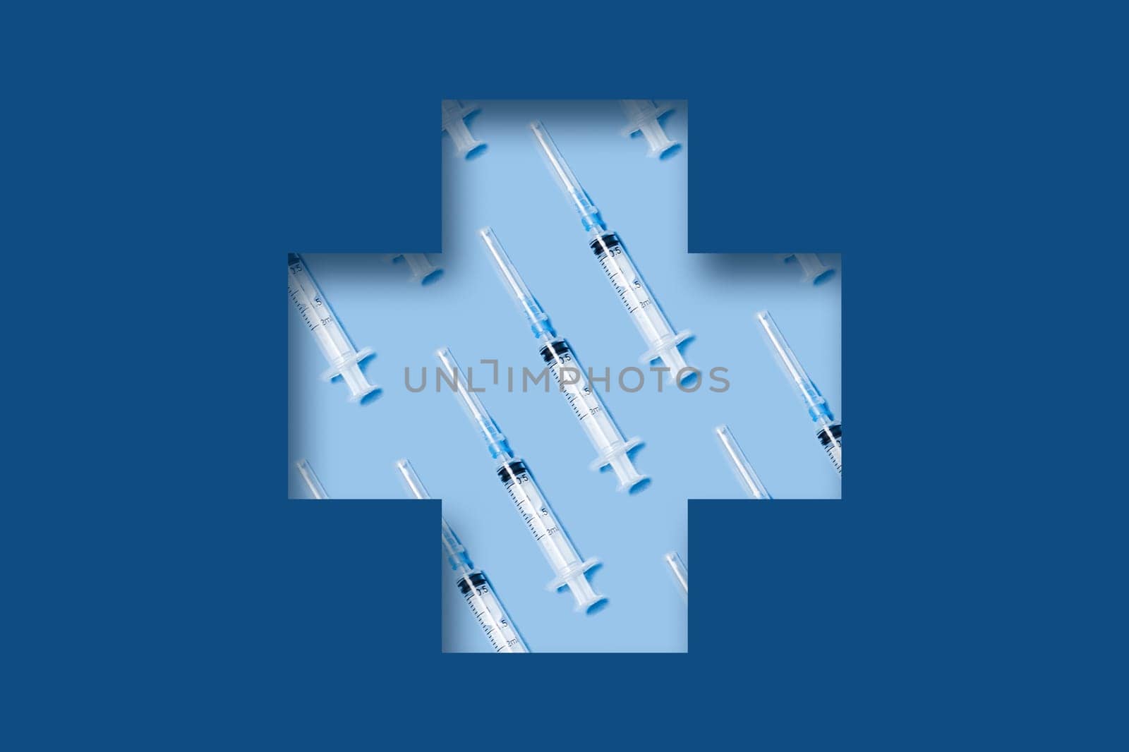3D paper cut out art. Medical classic blue background with syringes lying in a carved medical cross.