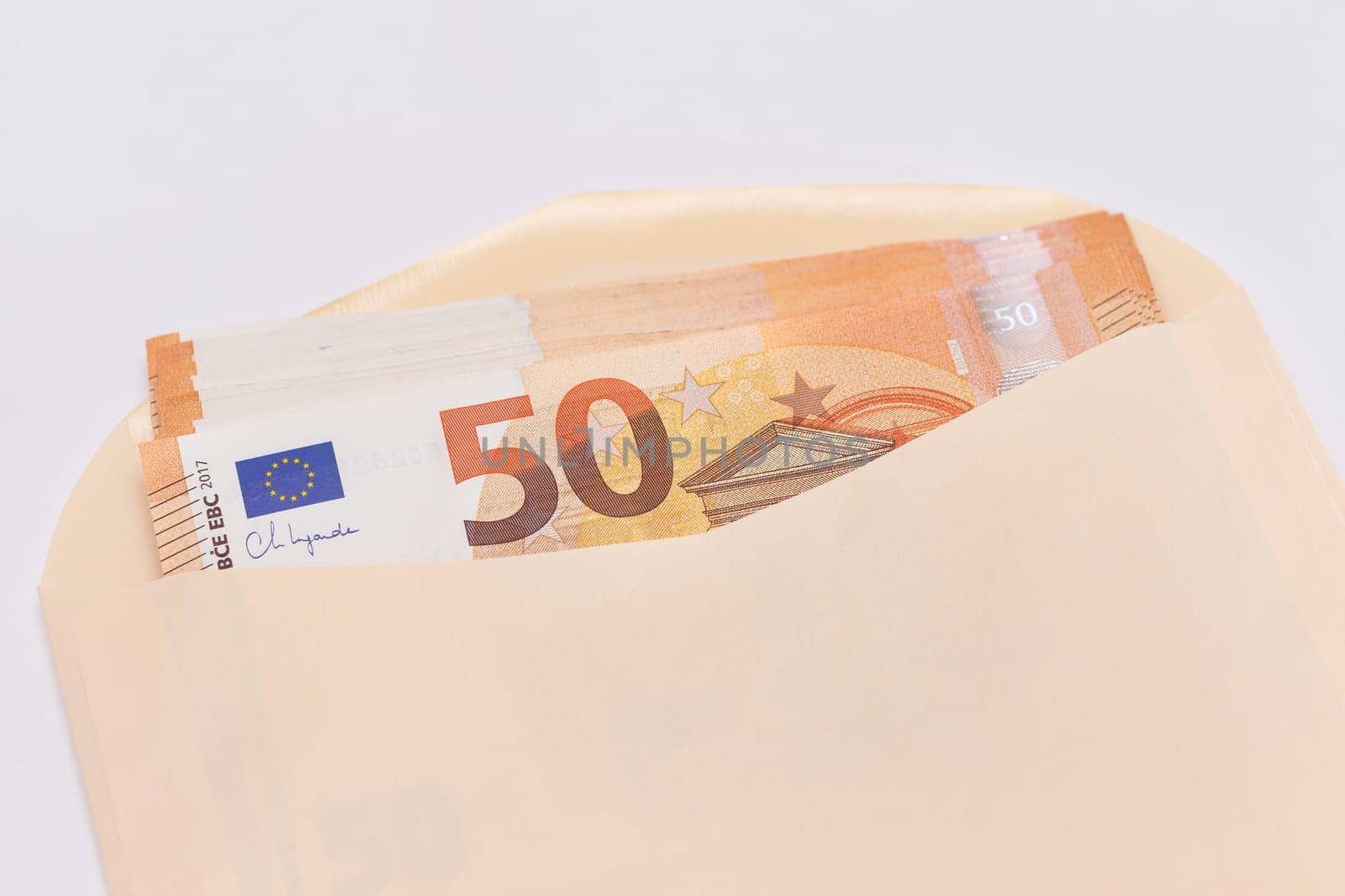 An Orange Paper Envelope with Stack of 50-Euro Banknotes Inside. Salary in Cash. Tax-Free System. Euro Currency. Payments with No Taxes. Orange Paper Money. A Lot of Fifty-Euro Bills