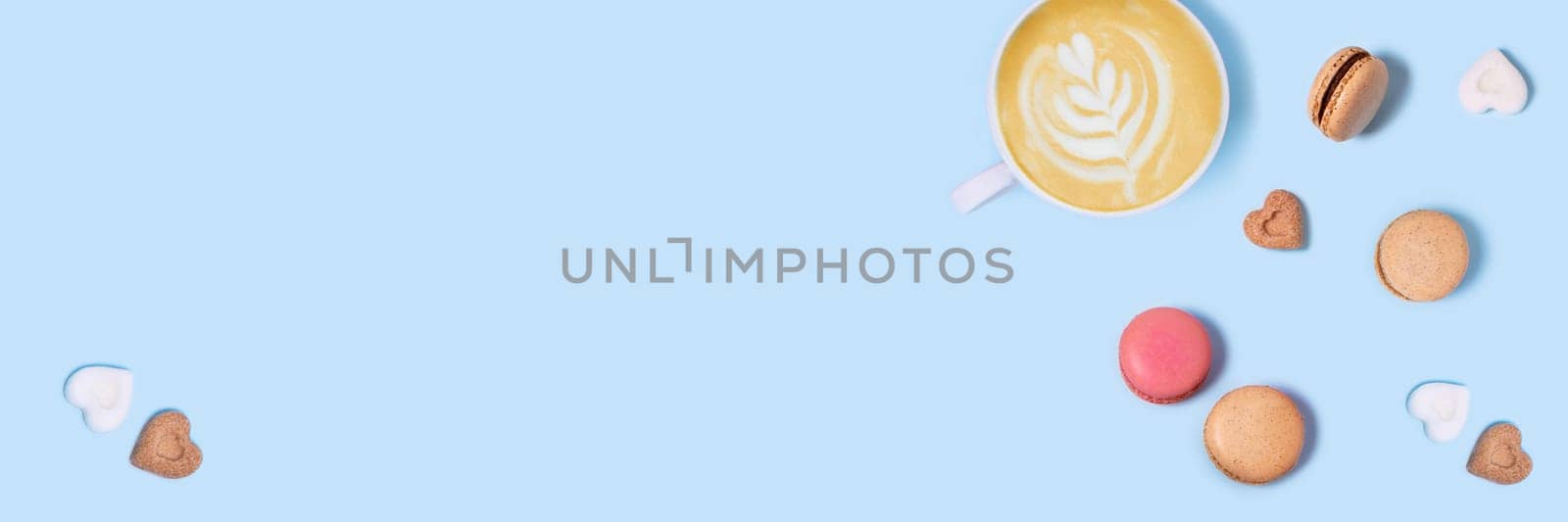 Blue background with macaroons and a Cup of coffee. Top view with space for your text.