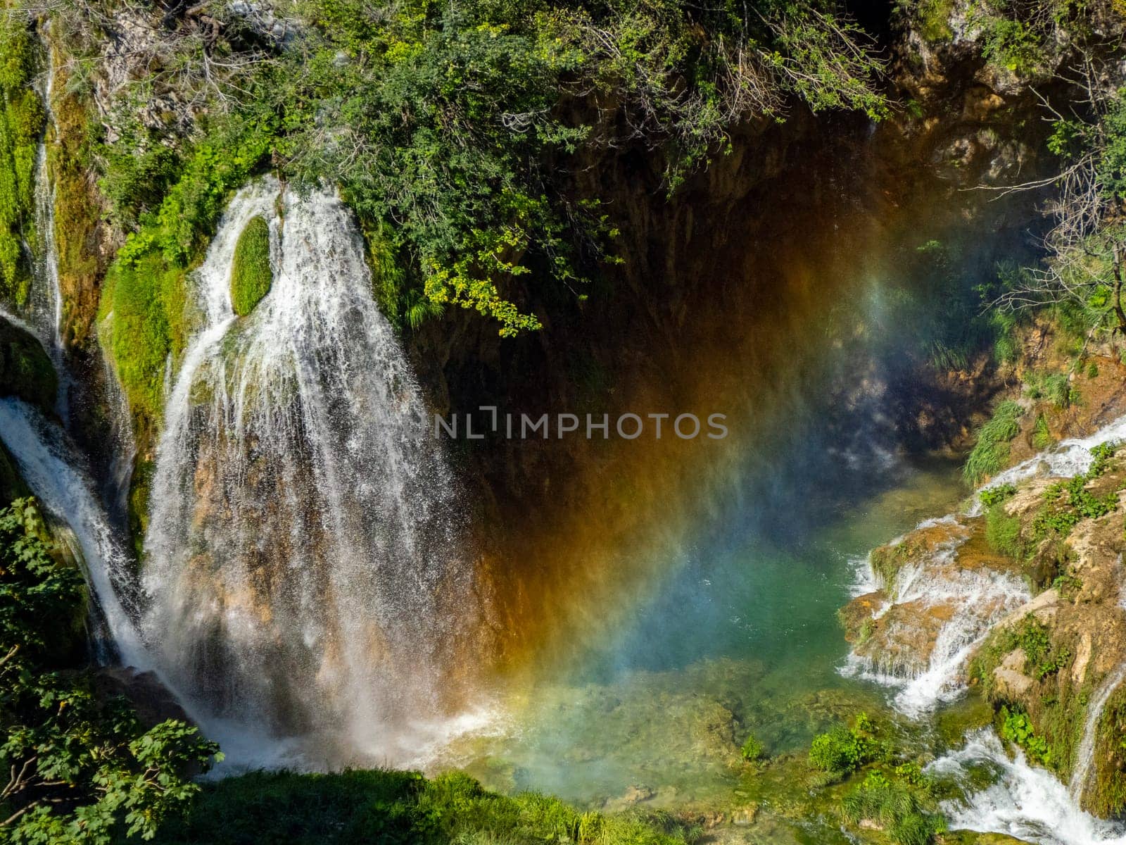 Summer view of water lakes and beautiful waterfalls in Plitvice Lakes National Park, Croatia rainbow coming from splashes and drops. by AndreaIzzotti