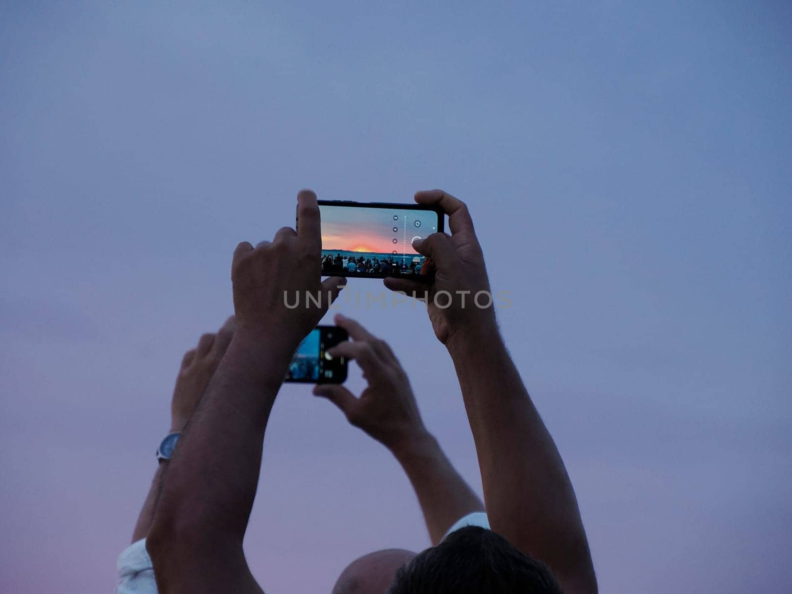 many people photographing red sunset