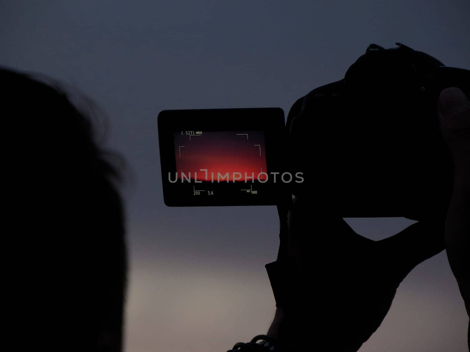 people photographing red sunset by AndreaIzzotti