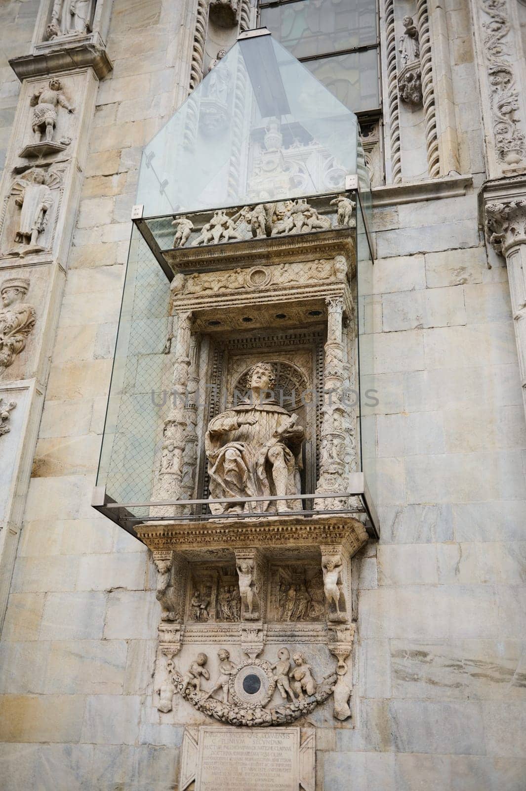 Exterior of the Cathedral in the city of Como, with Italian architectural details, sculpture, stone carvings, covered with a protective glass structure from external influences. Lombardy. Italy