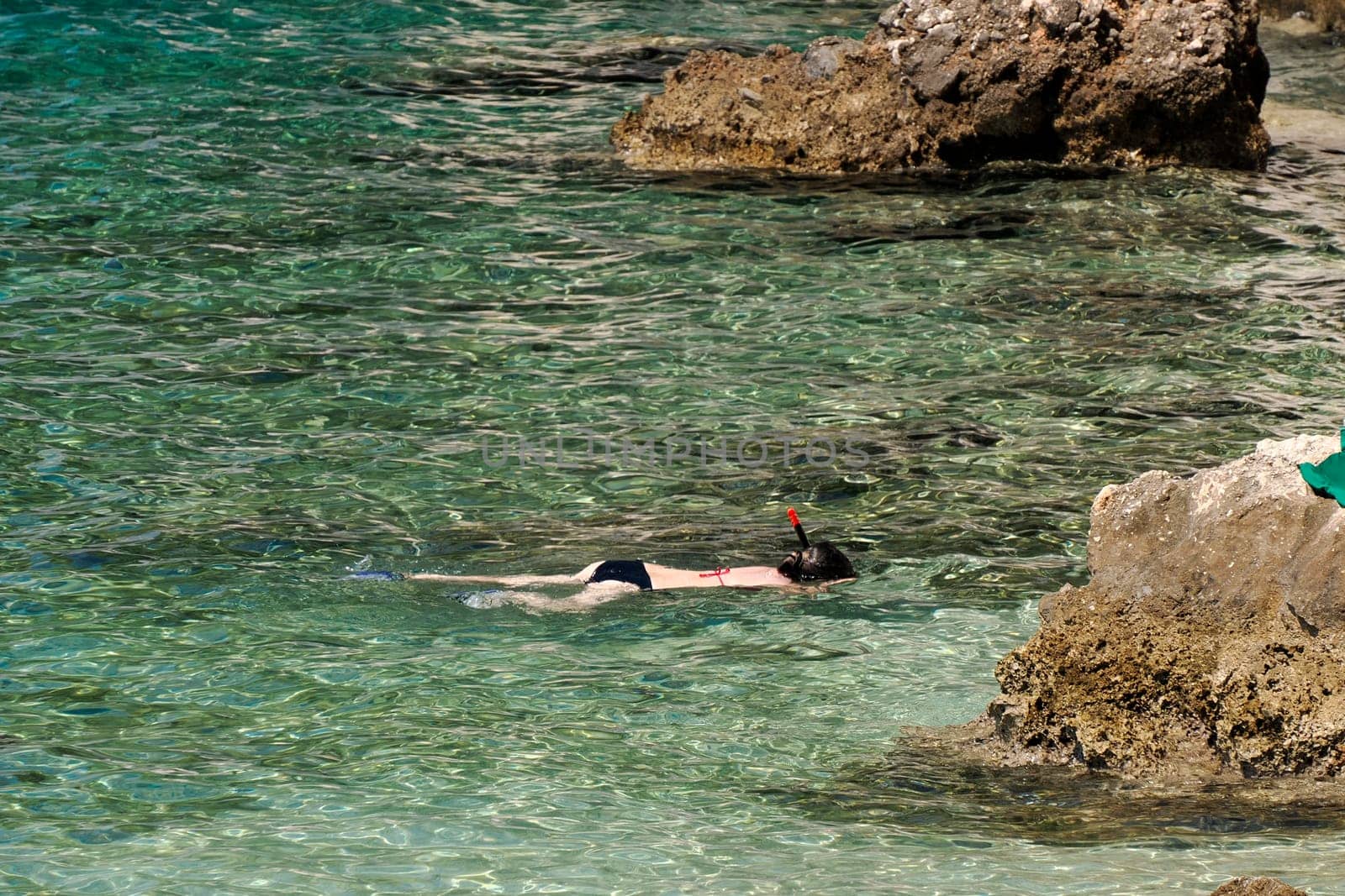 Snorkelist in crystal clear water of Adriatic sea in Brela on Makarska Riviera, Dalmatia, Croatia by AndreaIzzotti