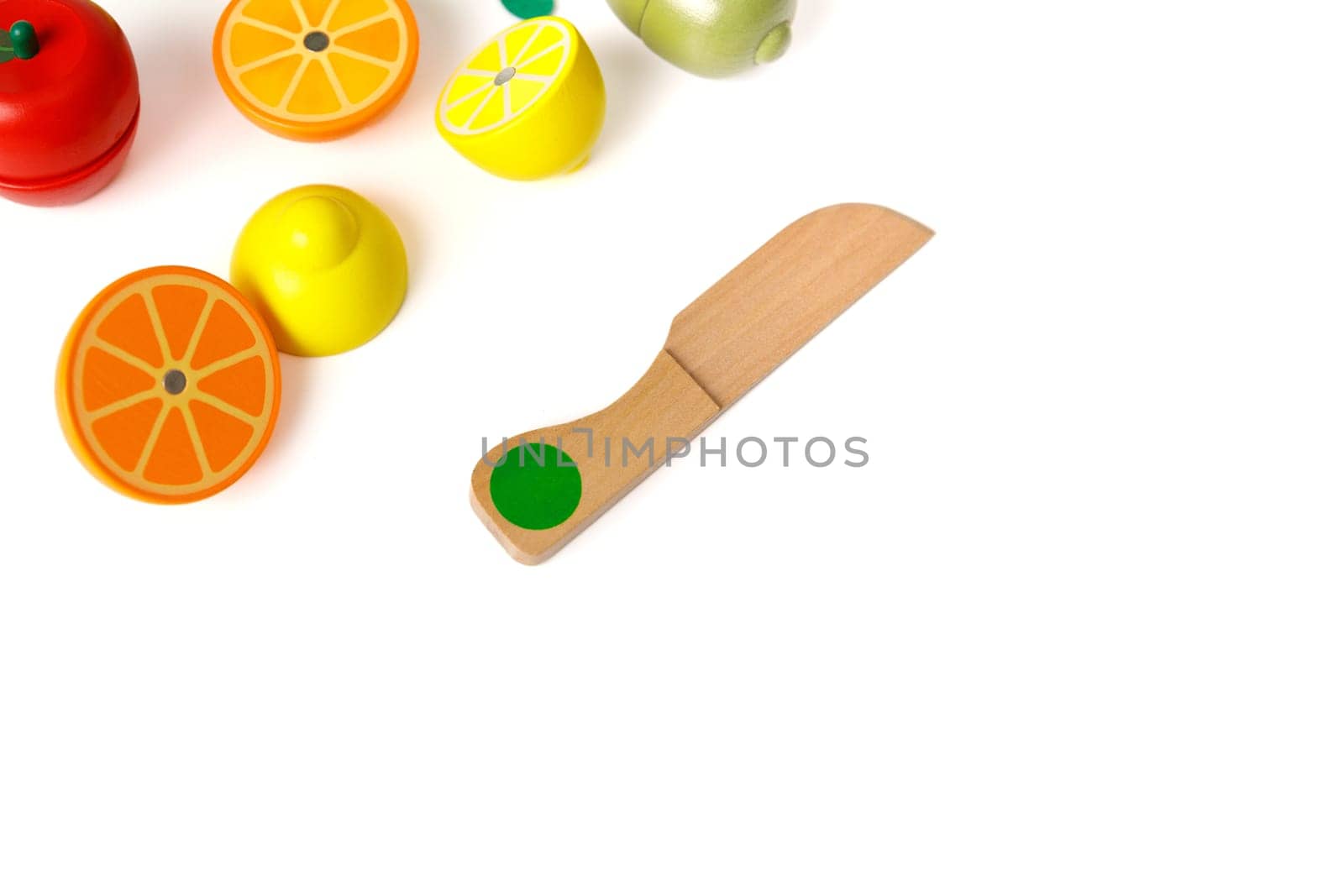 Educational toy set in the form of cut fruits and a wooden knife, isolated on white background, copy space.