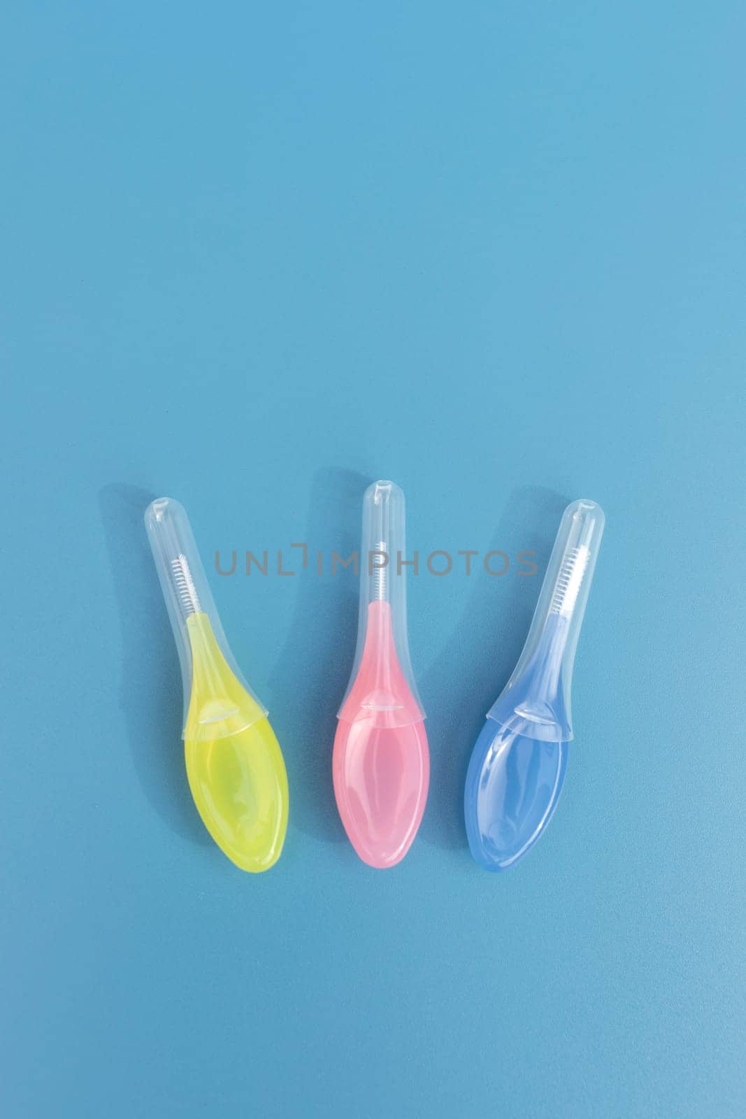 Template Colorful Dental Brushes Between Teeth Gum Braces on Blue Background, Interdental Brush Toothpick with Soft Bristles, Oral Tooth Cleaning Tool. Vertical Plane, Copy Space For Text. High quality