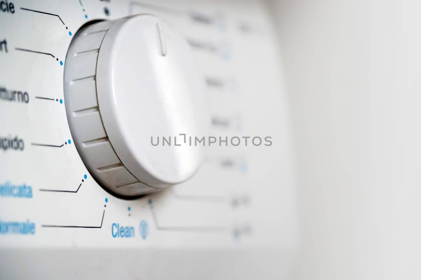 Washing machine with different modes of washing, spinning and rinsing clothes in the house, an assistant for hygiene and cleanliness, white control buttons close-up.