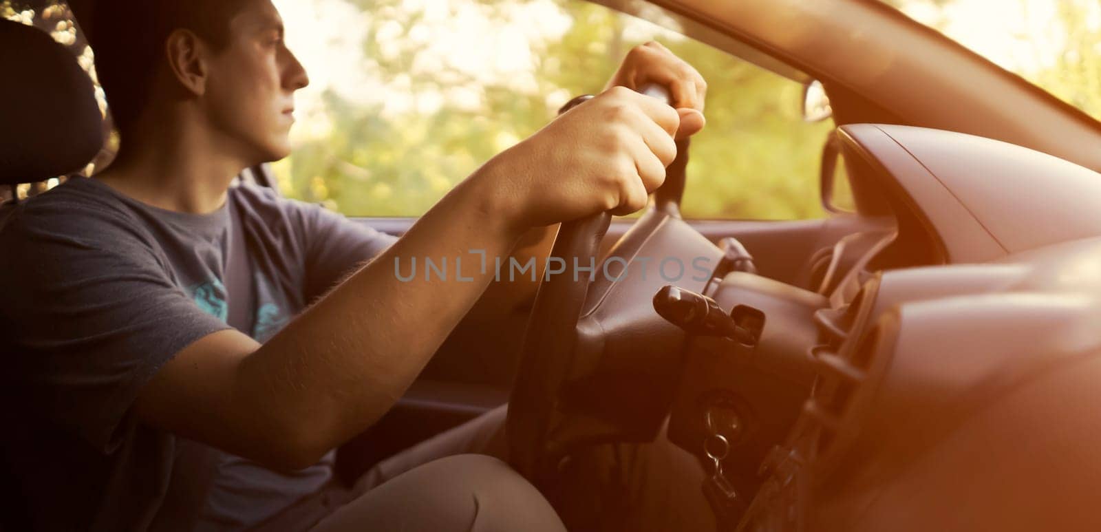 A man is driving a car, hands on the steering wheel closeup. by africapink