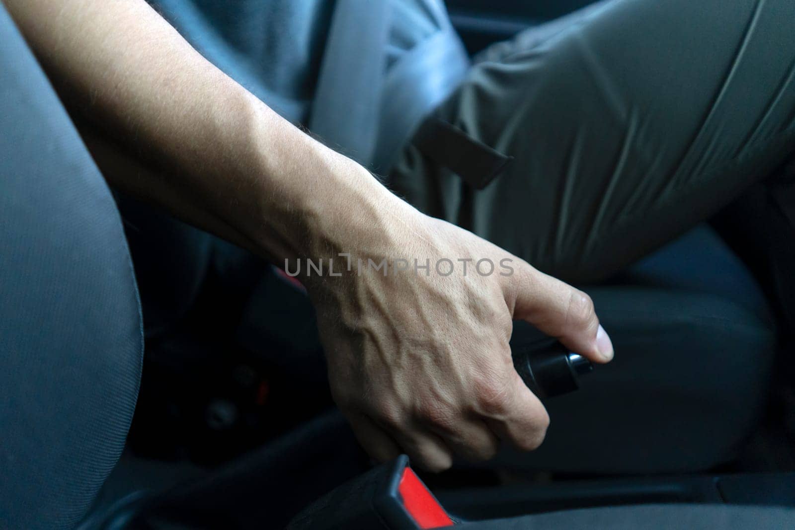 A man drives his car, slows down, keeps his hand on the handbrake and makes parking, hand close-up.