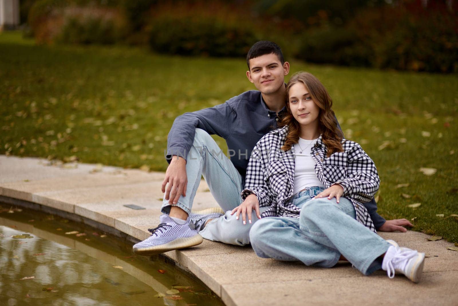 lovely young couple kissing outdoors in autumn. Loving couple walking in nature. Autumn mood. Happy man and woman hugging and kissing in autumn. Love. Fashionable couple outdoors. Fashion, people and lifestyle. Stylish couple in autumn outfit.