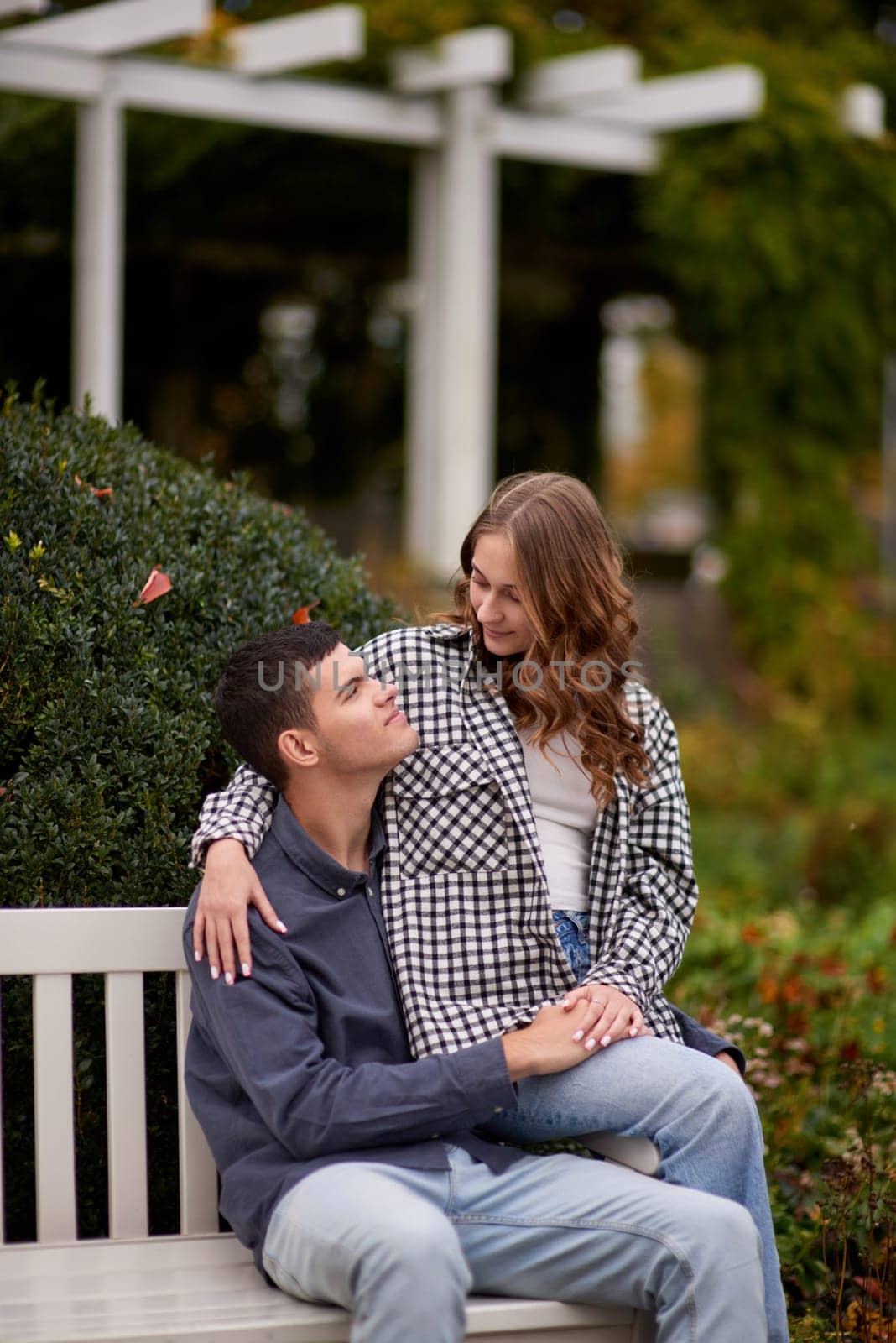 Autumn Romance: Young Couple Embracing and Kissing on Park Bench. Young couple kissing and rejoices at the lake. lovely young couple kissing outdoors in autumn. Embraced in Autumn's Warmth: Couple's Kiss on Park Bench. Loving couple walking in nature. Autumn mood. Happy man and woman hugging and kissing in autumn. Love. Fashionable couple outdoors. Fashion, people and lifestyle. Stylish couple in autumn outfit. by Andrii_Ko