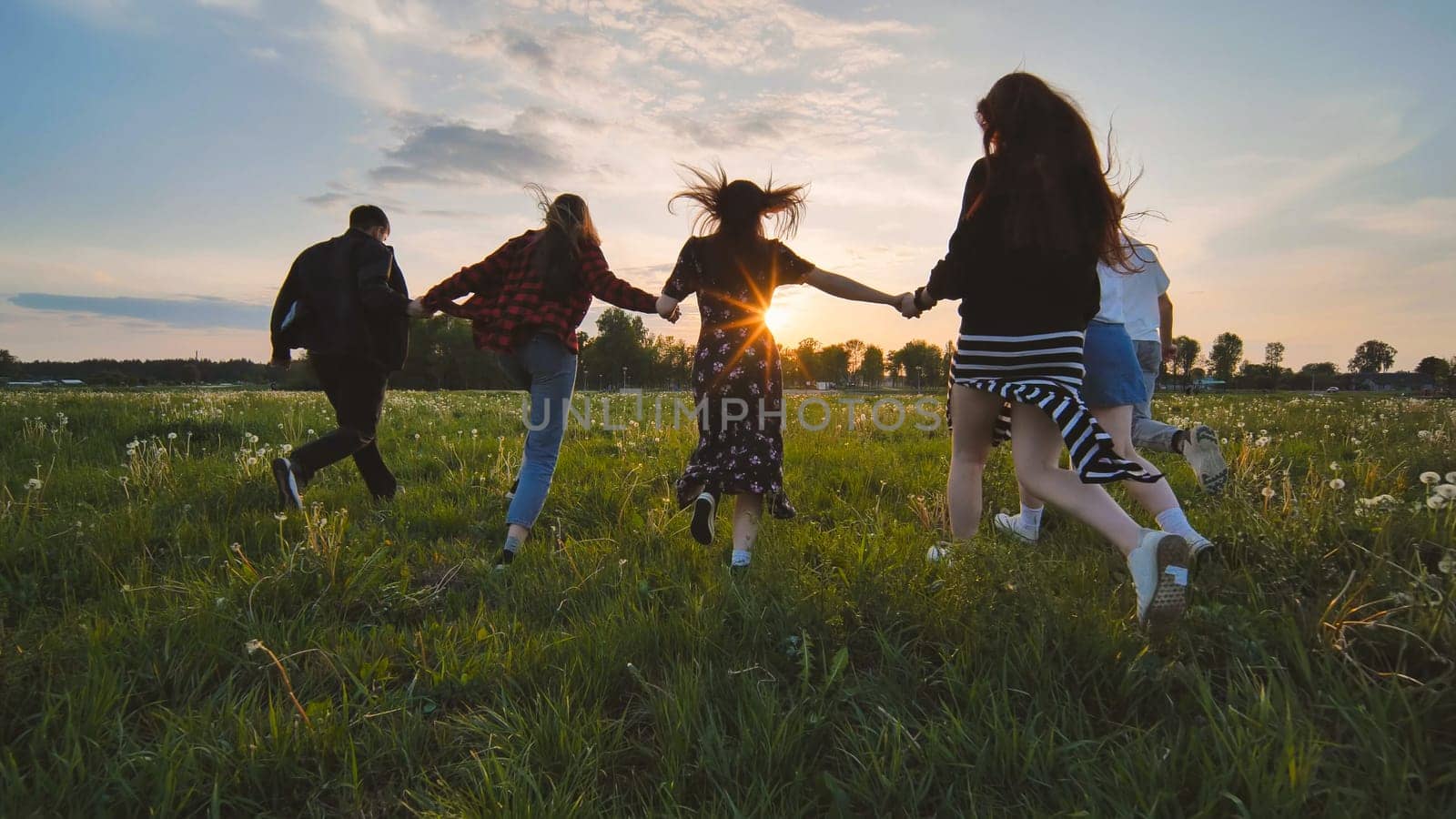 Merry friends run off into the sunset holding hands