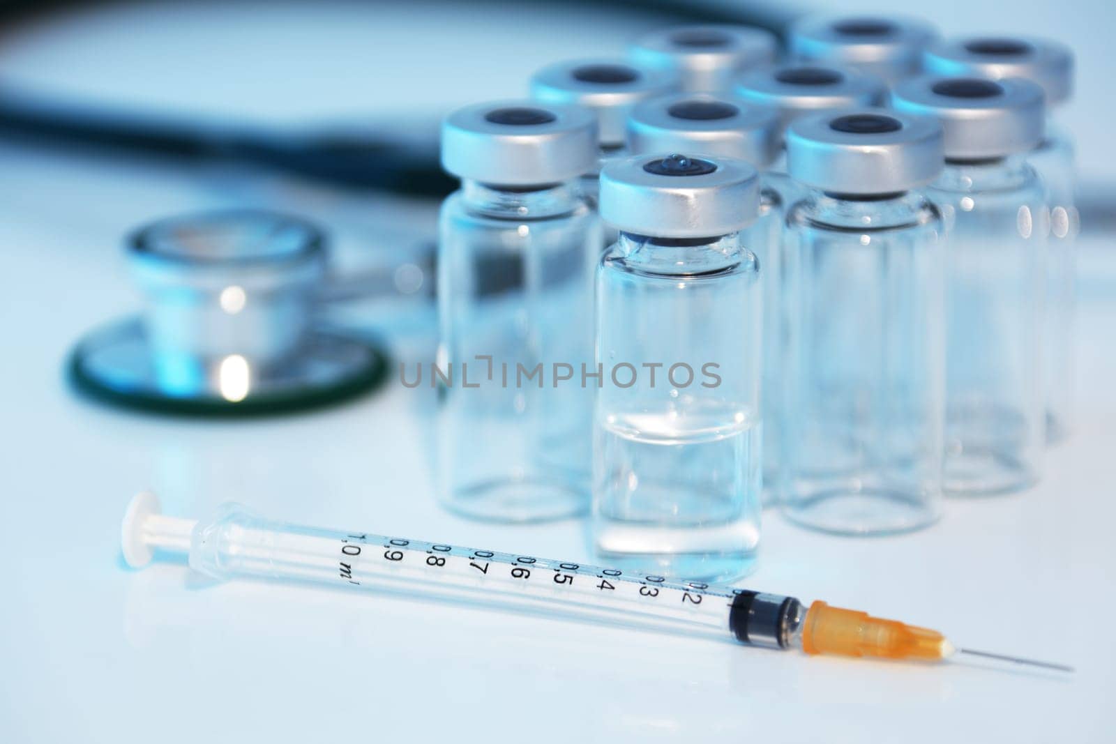 A medical syringe stethoscope and vaccine ampule bottles