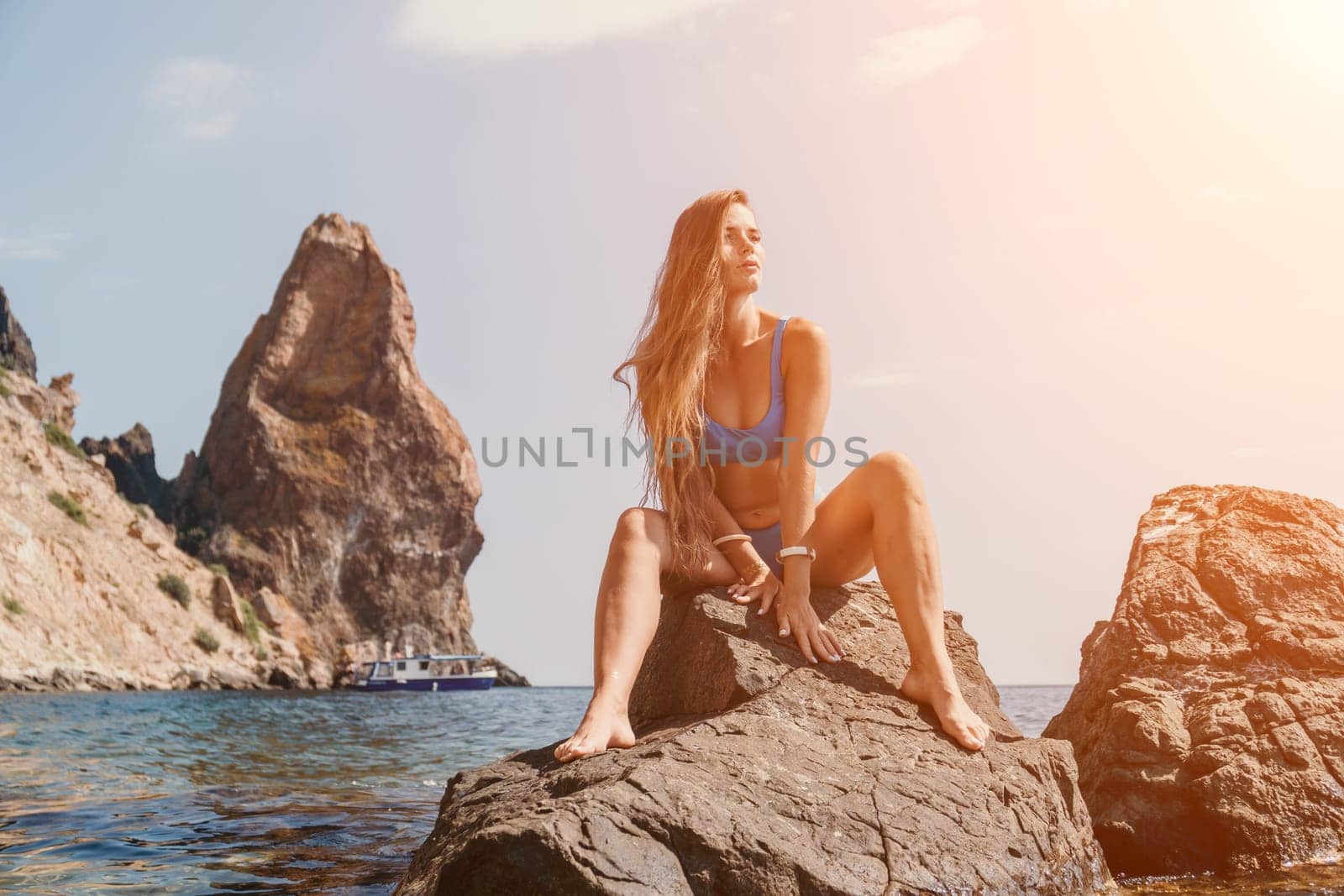 Woman summer travel sea. Happy tourist enjoy taking picture outdoors for memories. Woman traveler posing on the beach at sea surrounded by volcanic mountains, sharing travel adventure journey by panophotograph