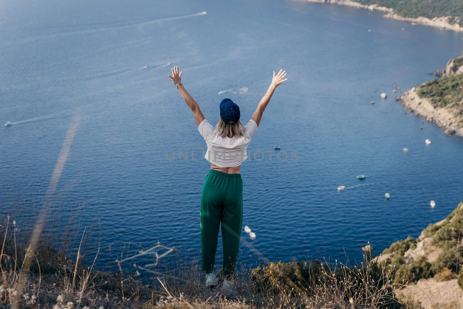 Happy woman standing with her back in nature in summer with open hands posing with mountains. Woman in the mountains, eco friendly, summer landscape active rest.