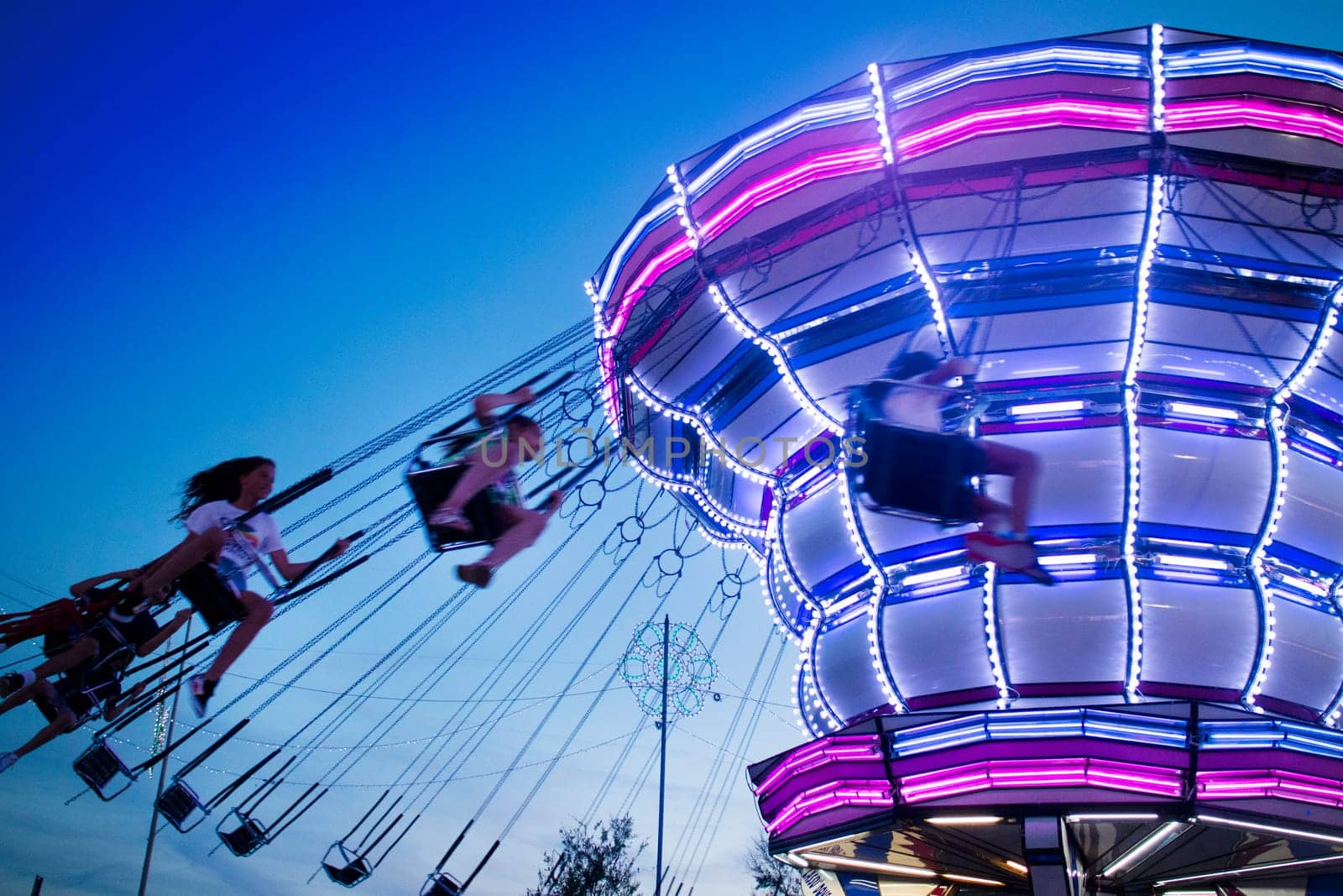 Evening shot of moving amusement park attractions by fotografiche.eu