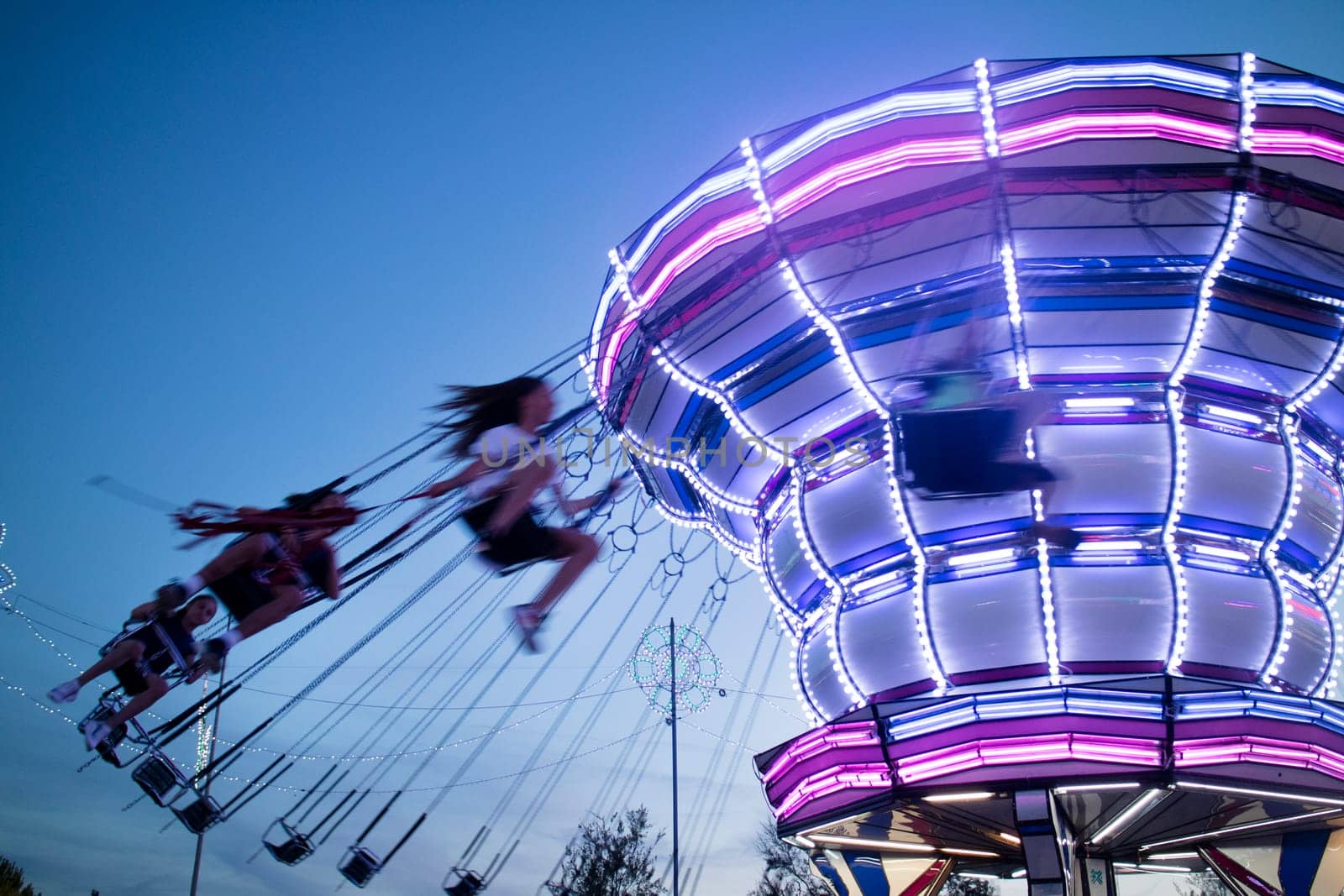 Evening shot of moving amusement park attractions by fotografiche.eu