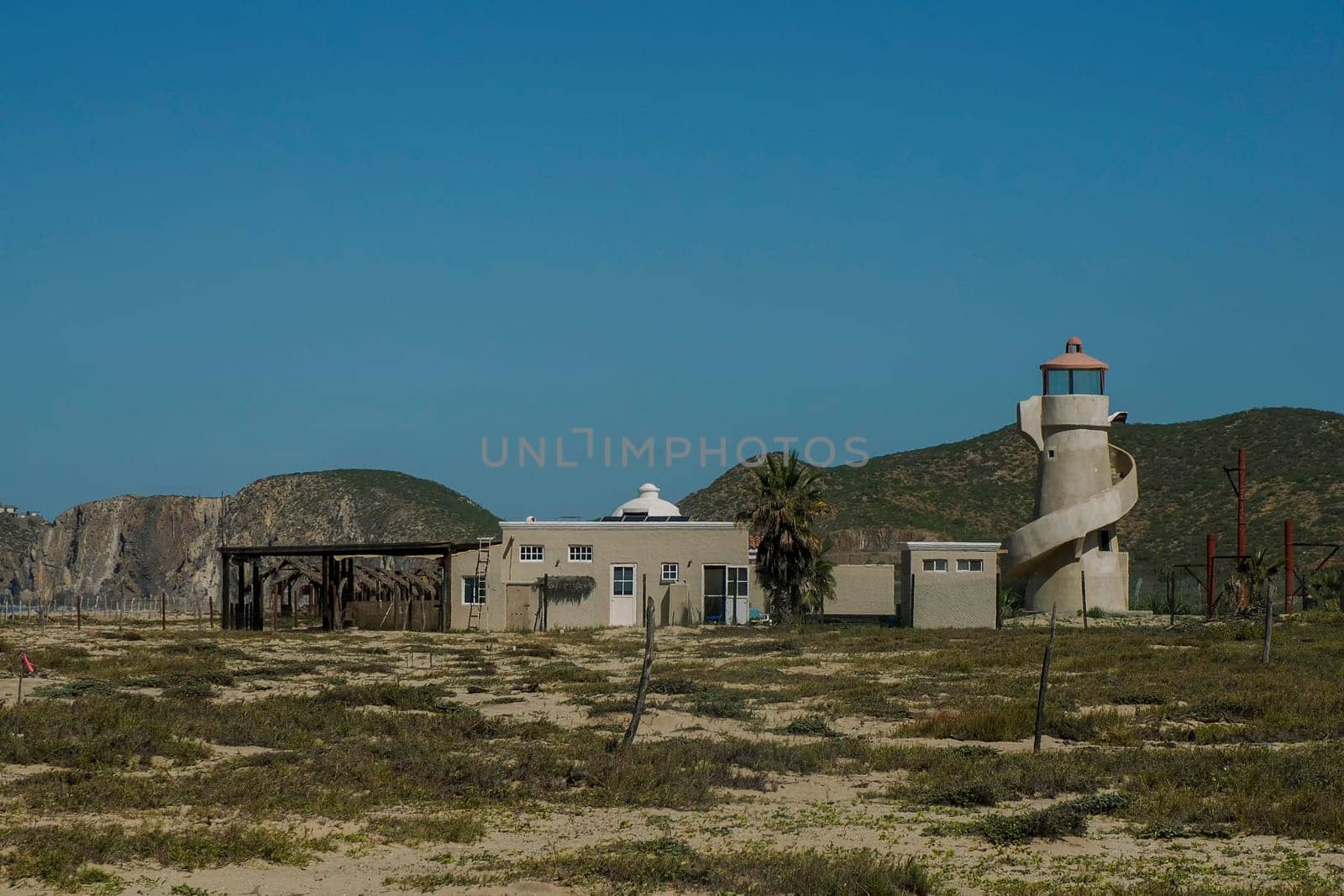 Abandoned lighthouse in Pacific Ocean beach of baja california sur landscape from boat by AndreaIzzotti