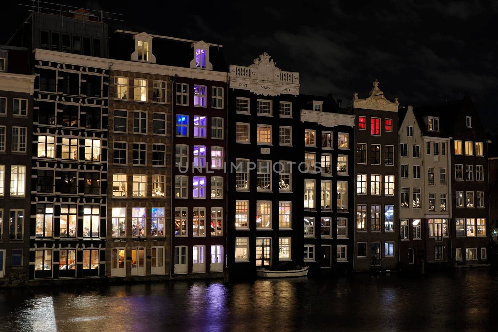 amsterdam ancient buildings over canals at night by AndreaIzzotti
