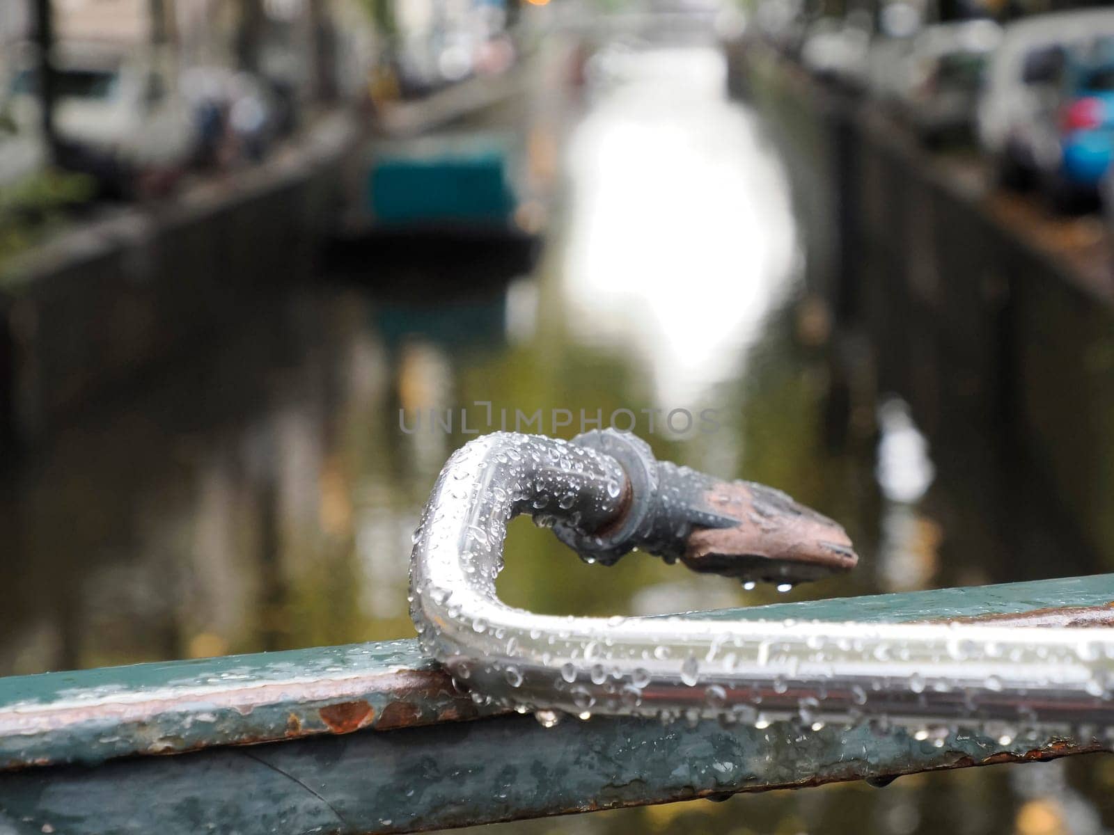 bicycle handlebar on canals of Amsterdam view on rainy day by AndreaIzzotti
