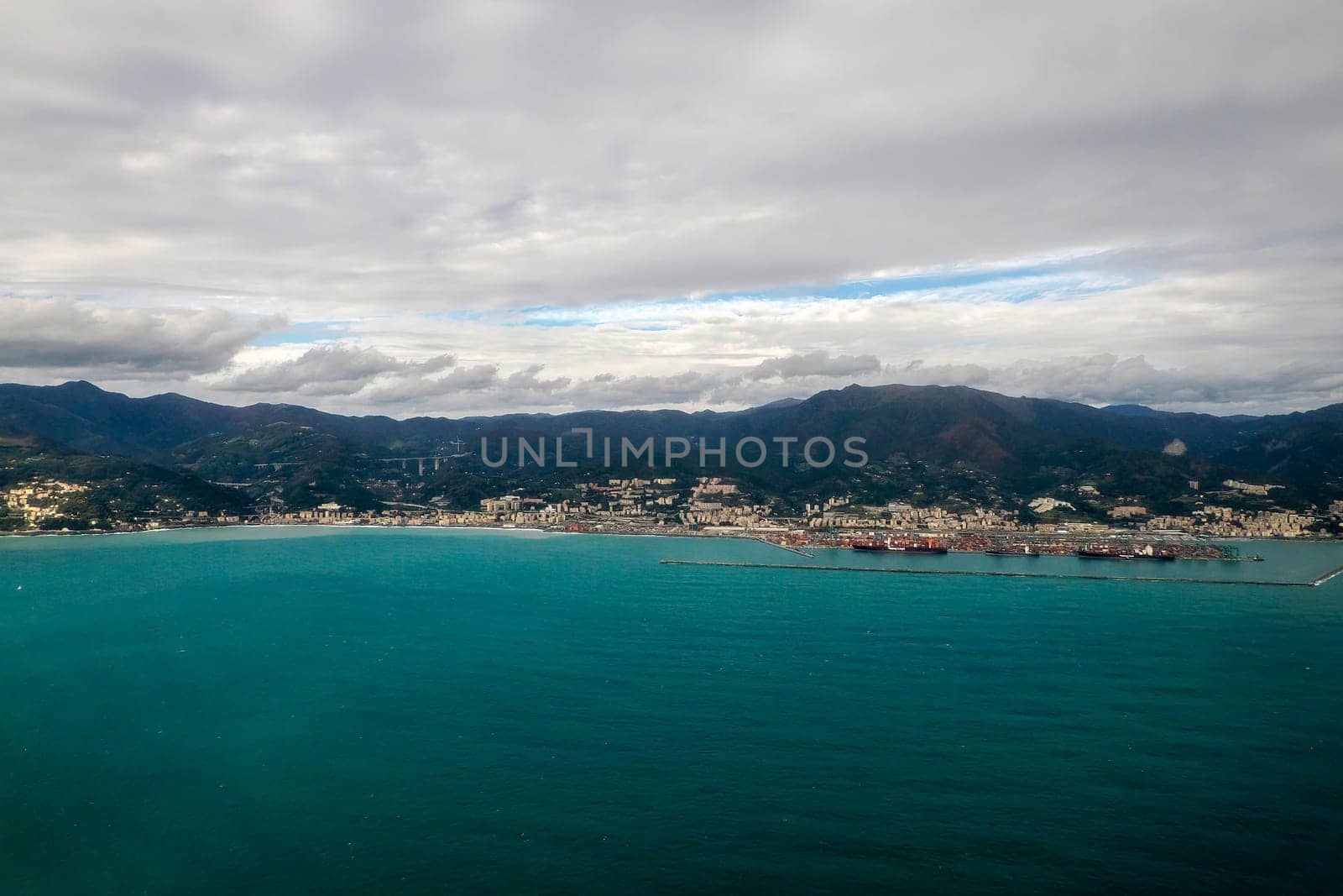 Airport of Genoa aerial view before landing to airport by airplane during a sea storm tempest hurricane by AndreaIzzotti