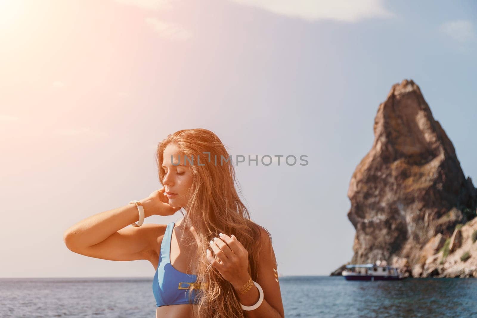 Woman summer travel sea. Happy tourist enjoy taking picture outdoors for memories. Woman traveler posing on the beach at sea surrounded by volcanic mountains, sharing travel adventure journey by panophotograph