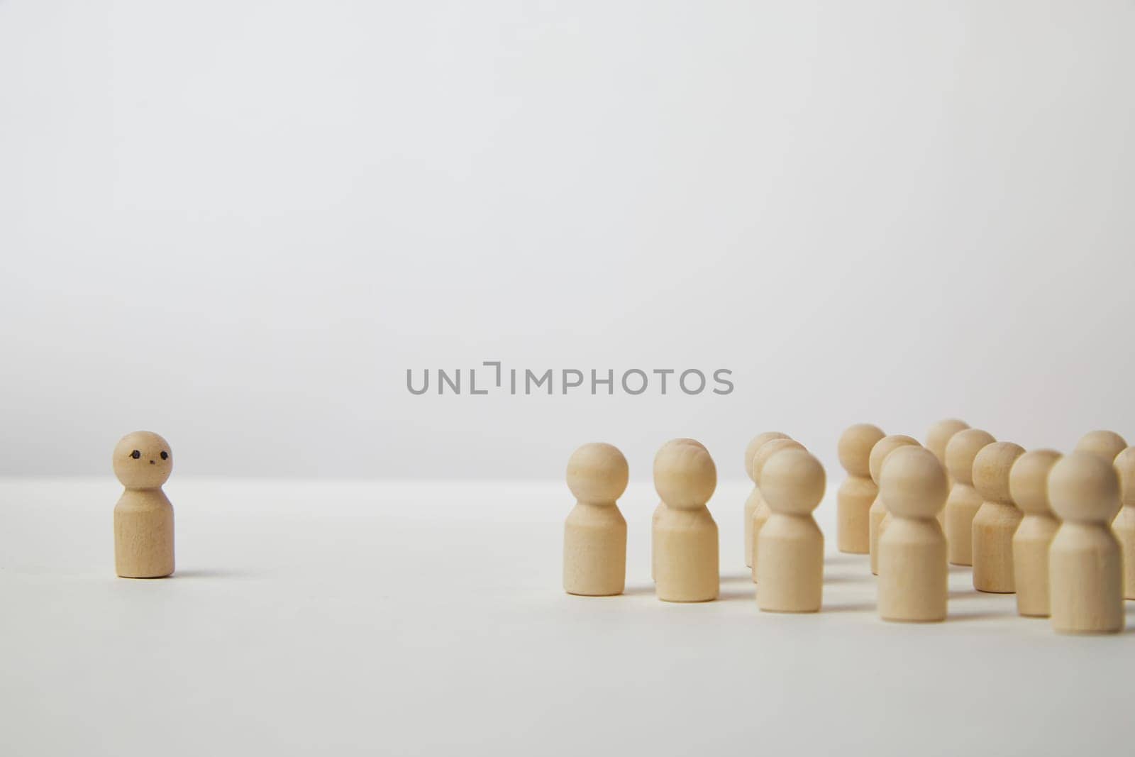 Wooden figurines with a leader and group with partial focus. The confrontation between the head and the employees. Outcast, different, different. Bullying at school, at work