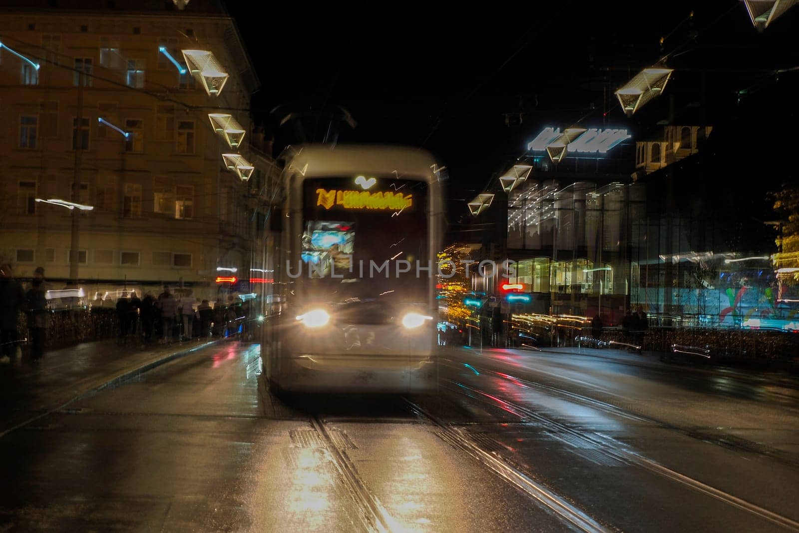 Night moving Trolley tram in graz austria tracks and cables in winter season by AndreaIzzotti