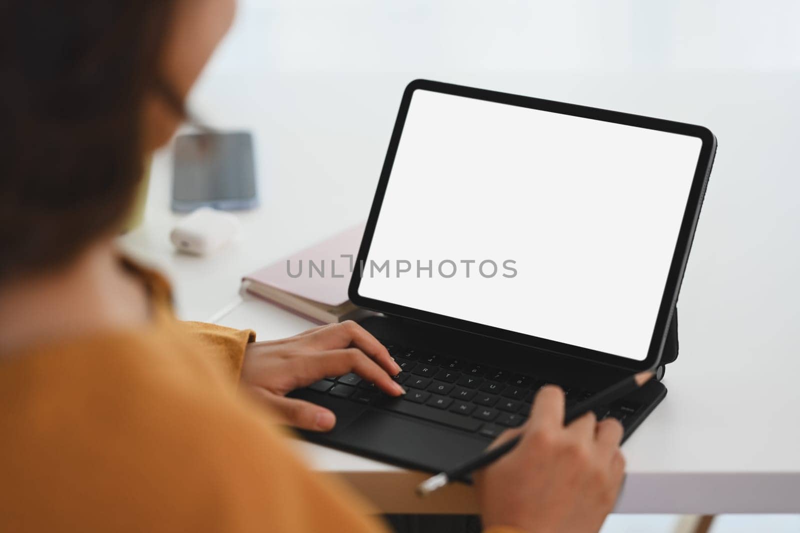 Smiling young female freelancer working with digital tablet on desk at home