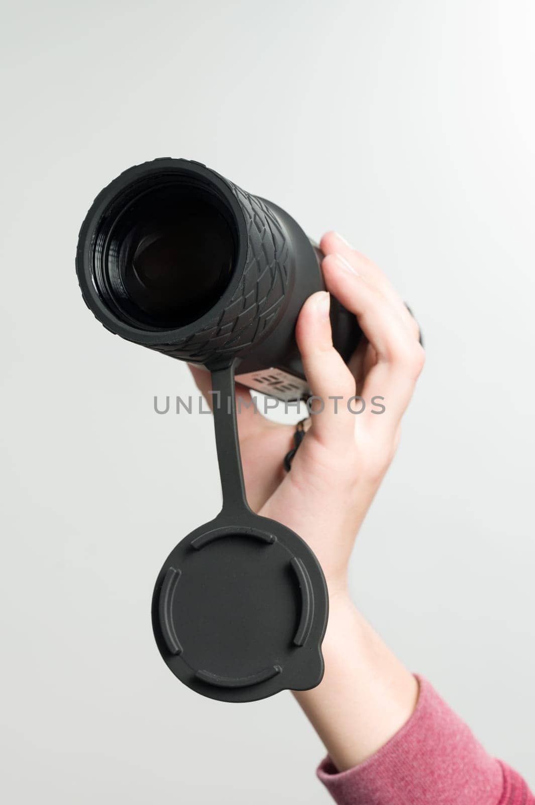 The child is holding a monocular on a white background, a long-range thermal imager.