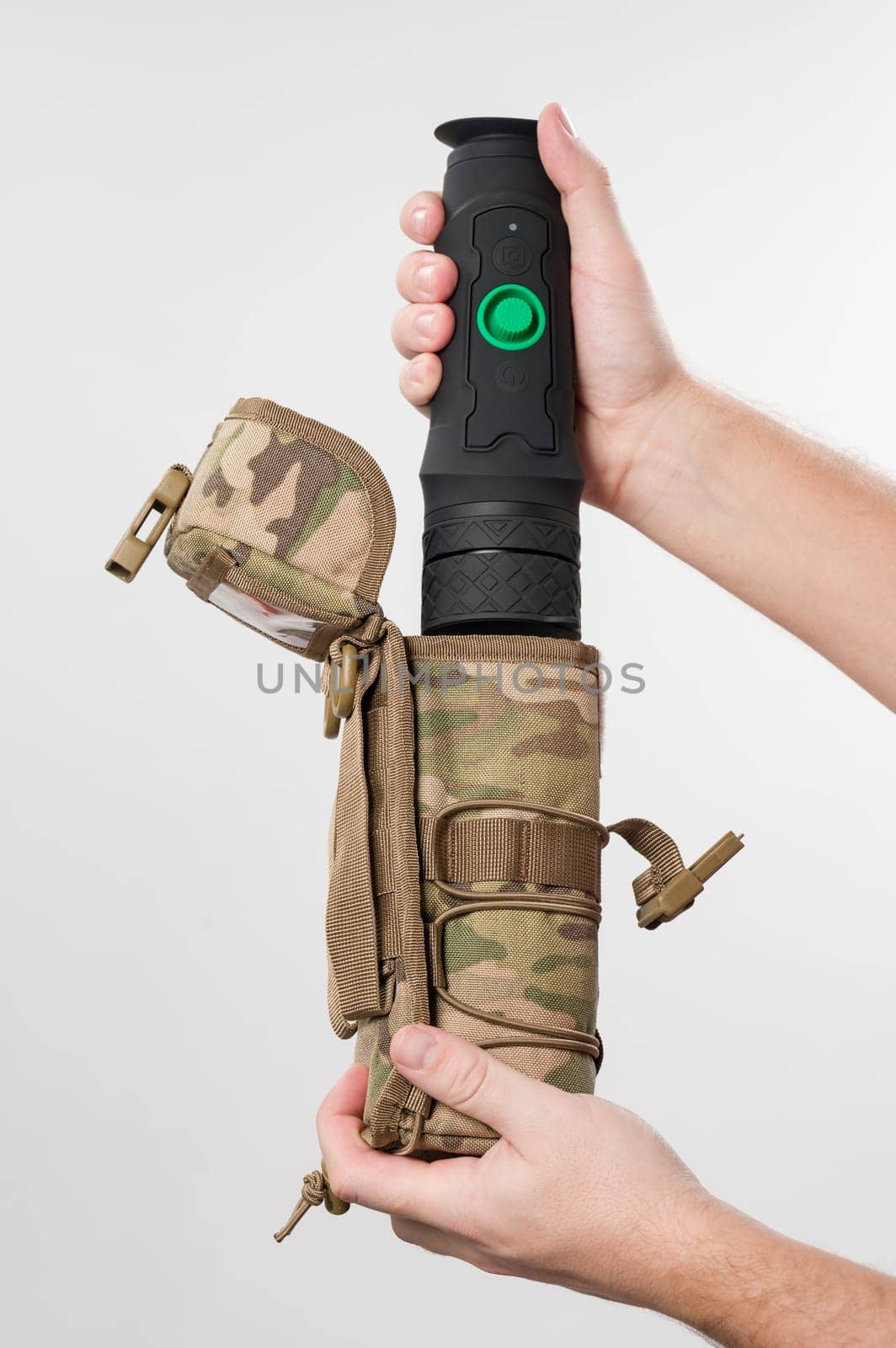 Military monocular in a case for storage and carrying, a man demonstrates a monocular in a protective case to a bag in pixels.
