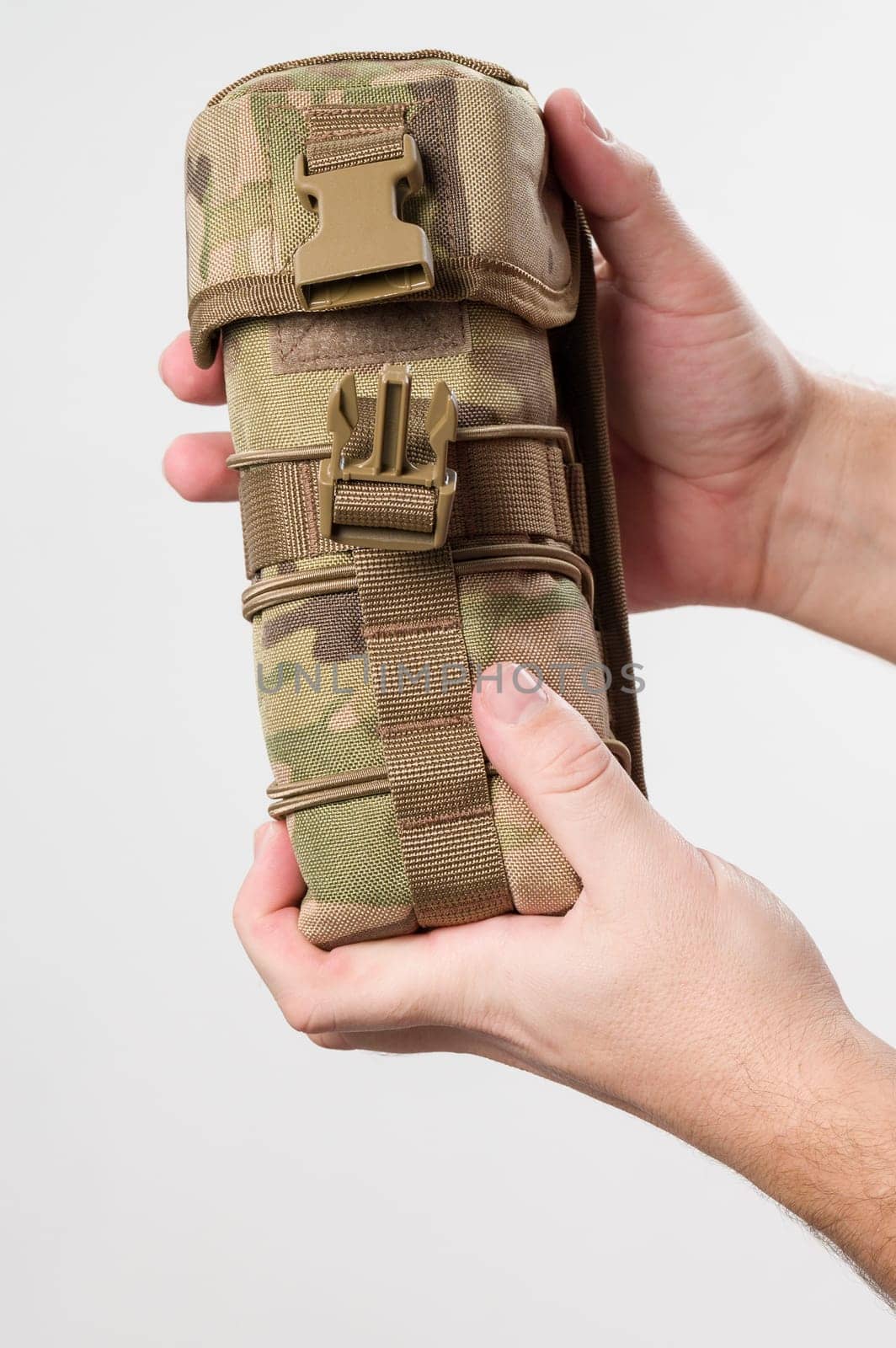 A man holds a protective cover for a monocular, pixelated fabric for the military. by Niko_Cingaryuk