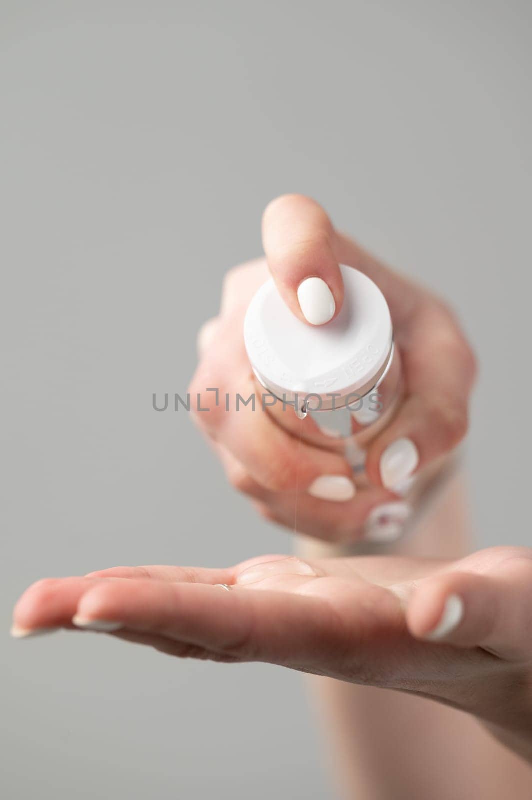 A girl in the bathroom takes care of her skin and applies cream to her body, cosmetologist squeezes cream from a jar on the hand, hand and face skin care.