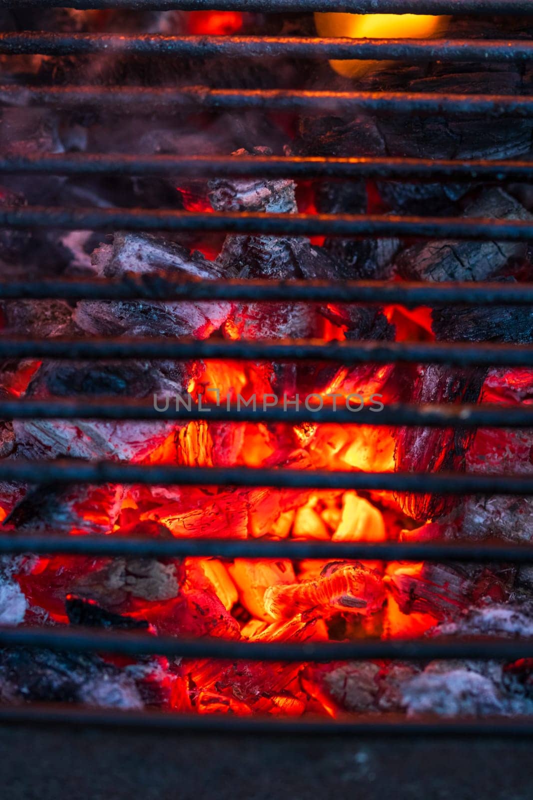 Barbecue grill pit with glowing and flaming hot charcoal briquettes